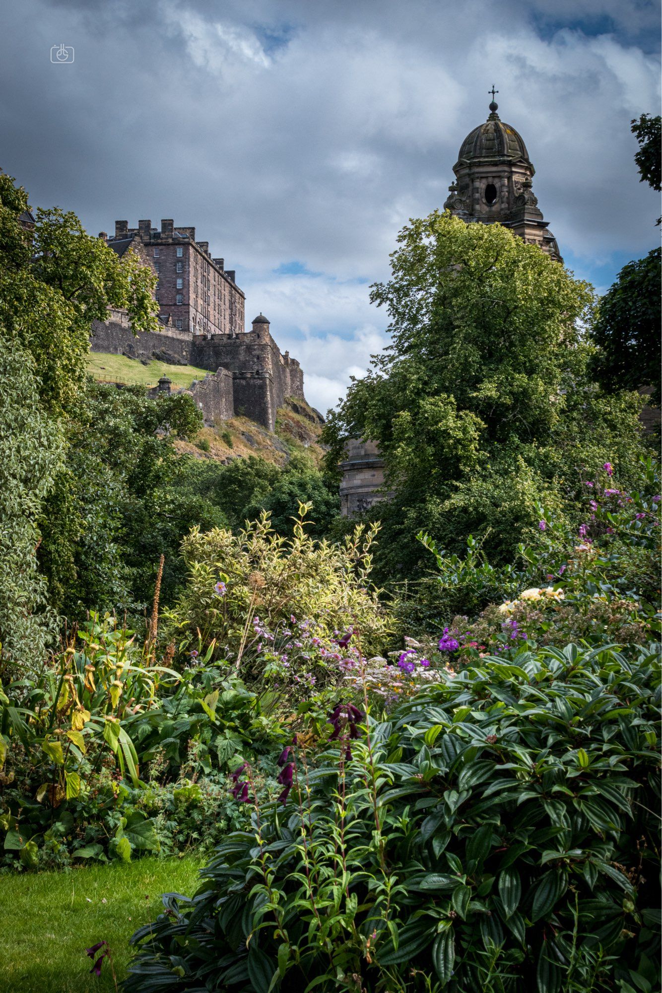 A naturalistic garden with Edinburgh Castle and a tower of St. Cuthbert’s Church in the background. Princes Street, Edinburgh, 22 Aug 2024. Nikon D5600, Nikkor DX 35 mm ƒ1.8G, ISO 800, ƒ16, -0.3 ev, 1/125s, polarizing filter