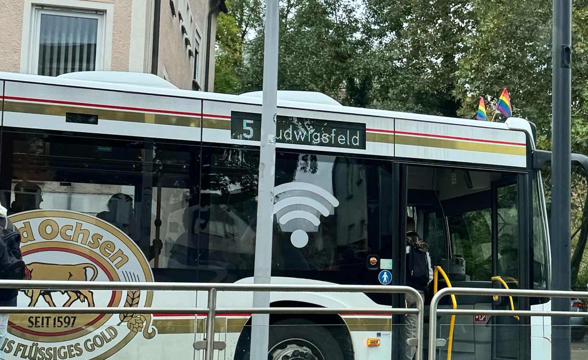 Bus No. 5 mit Regenbogenfahnen auf dem Dach über der Windschutzscheibe