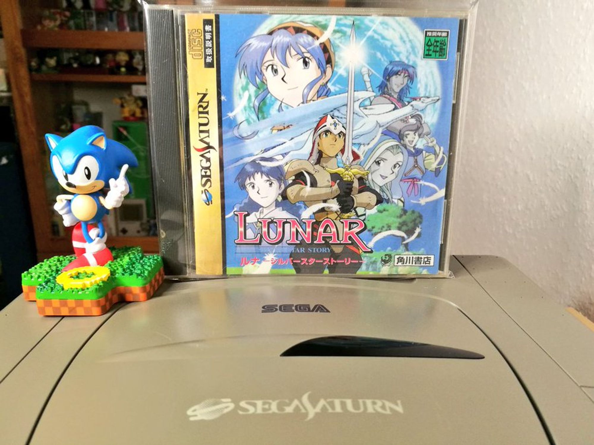 Lunar Silver Star Story für Sega Saturn steht neben einer Sonic Figur auf einem japanischen Saturn