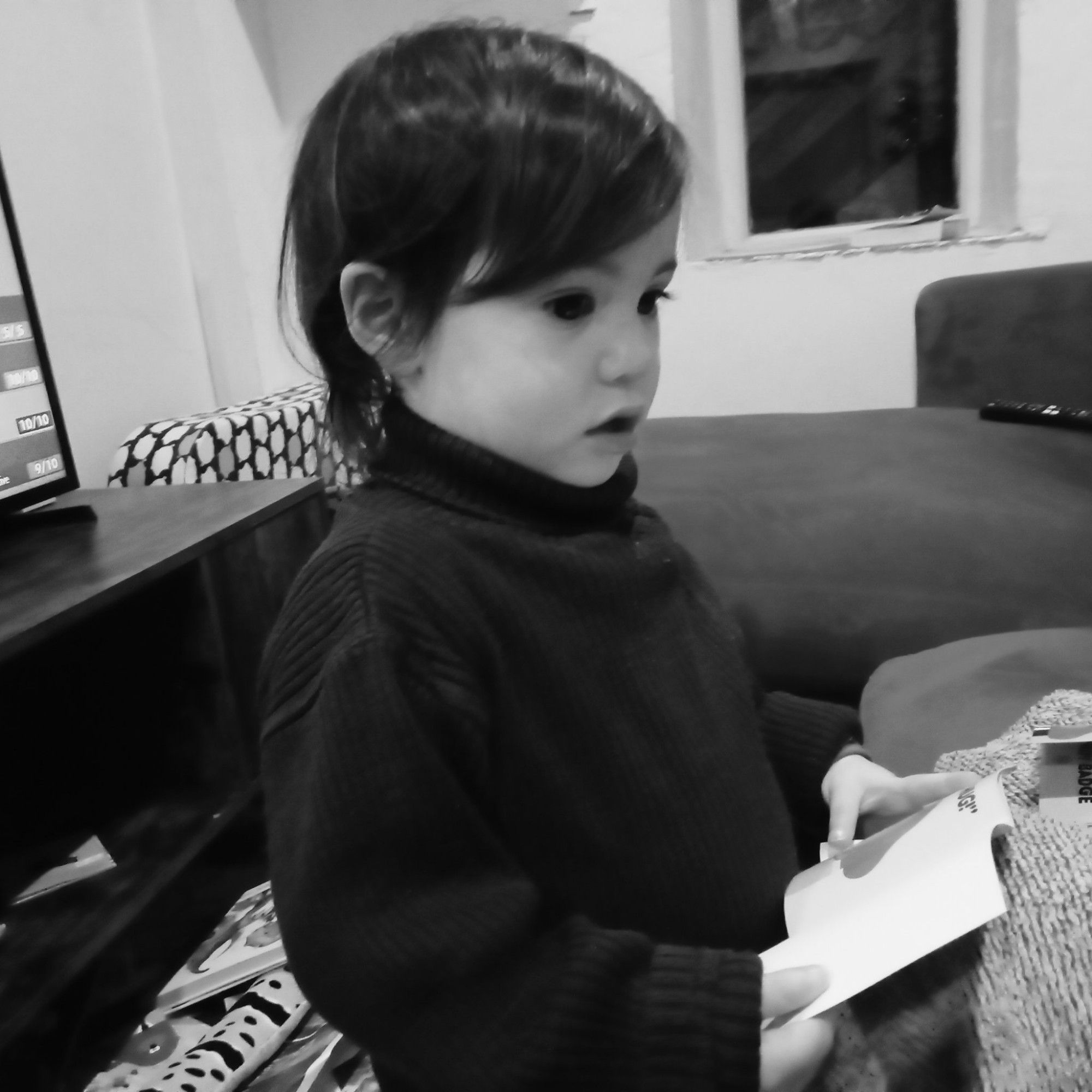 black and white photograph of a toddler wearing a black turtleneck jumper