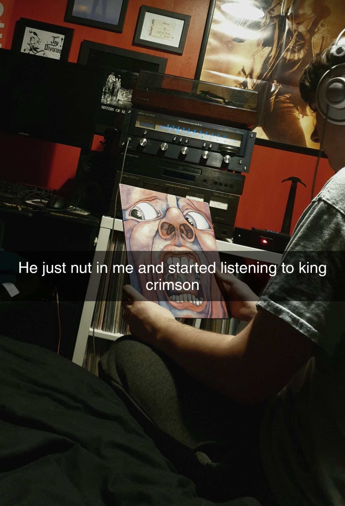 Imagem de um jovem sentado na beira da cama com fone de ouvido e segurando o disco In the Court of the Crimson King da banda King Crimson. O texto na imagem diz: "He just nut in me and started listening to king crimson."