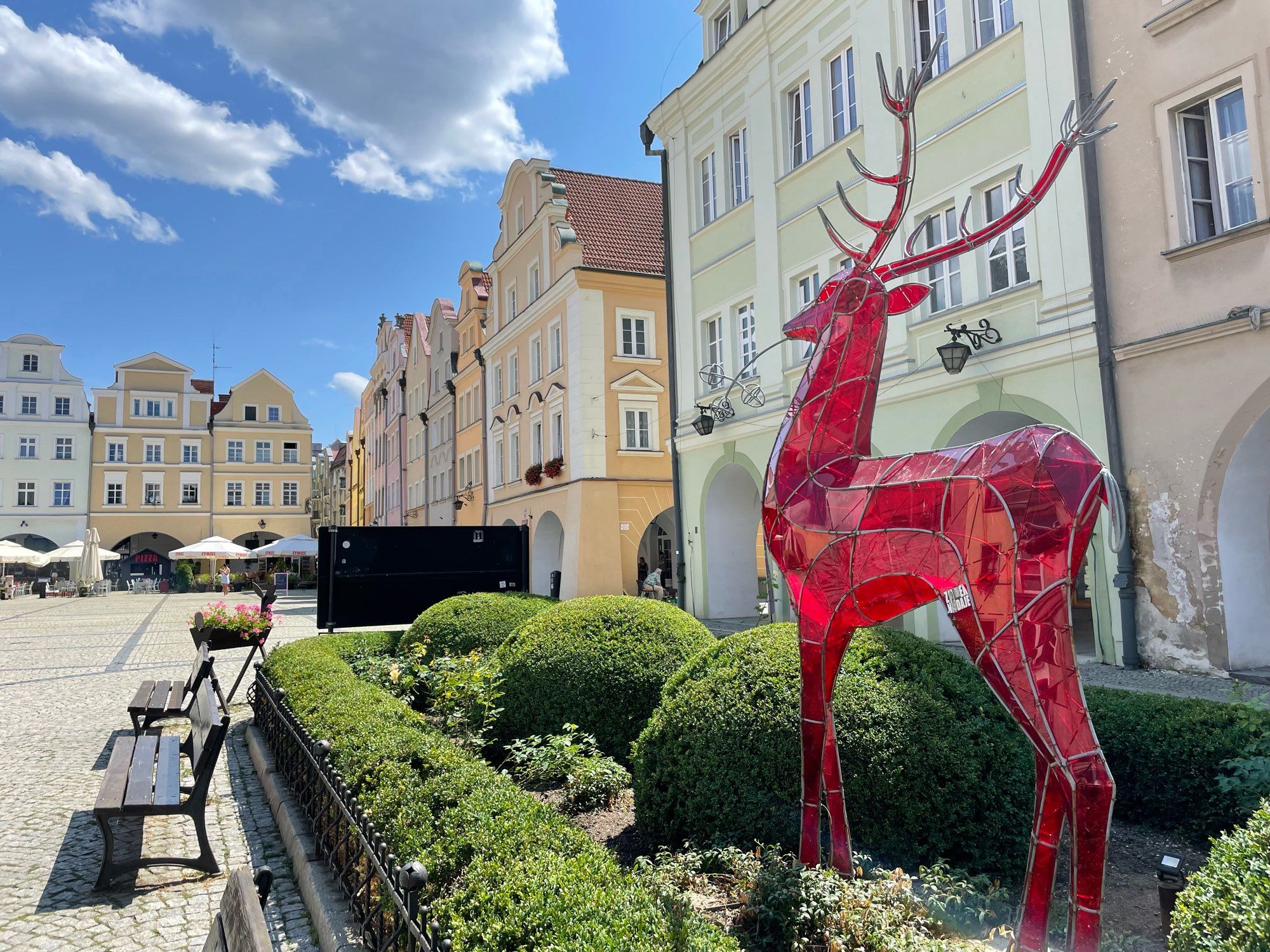 Der Hirsch aus rotem Glas schaut auf den Platz