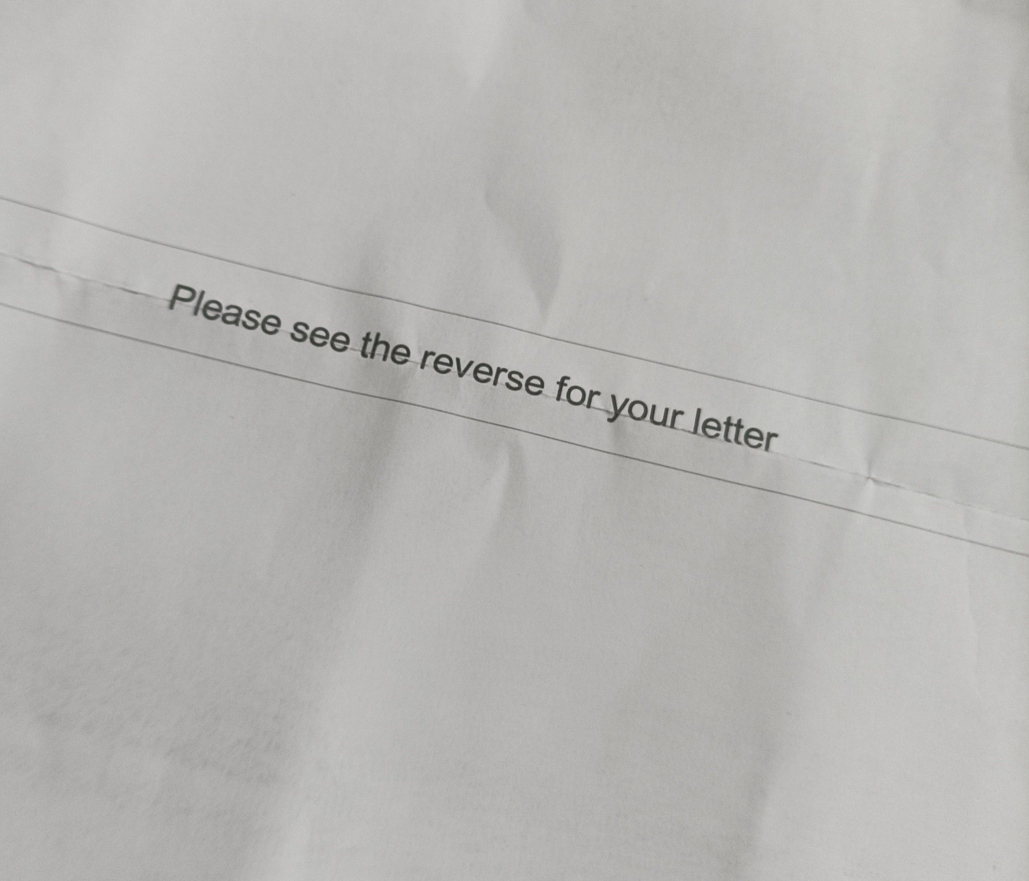 "please see the reverse for your letter" printed on the blank back page of an official letter.