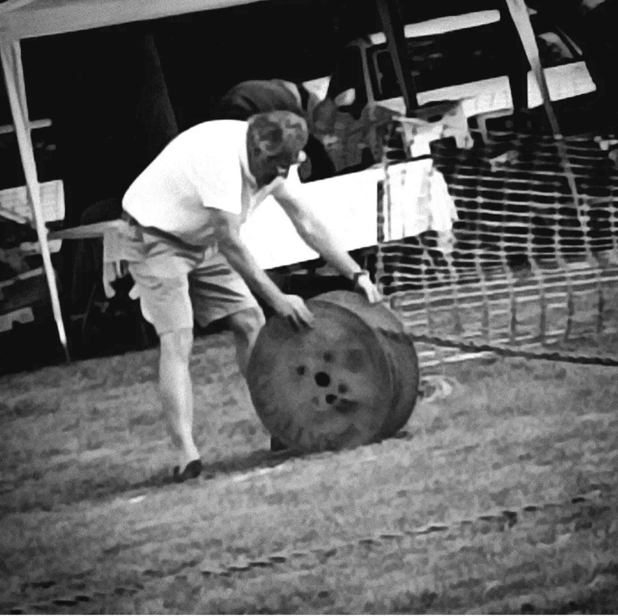 Black and white picture of a man reeling in a tug of war rope.