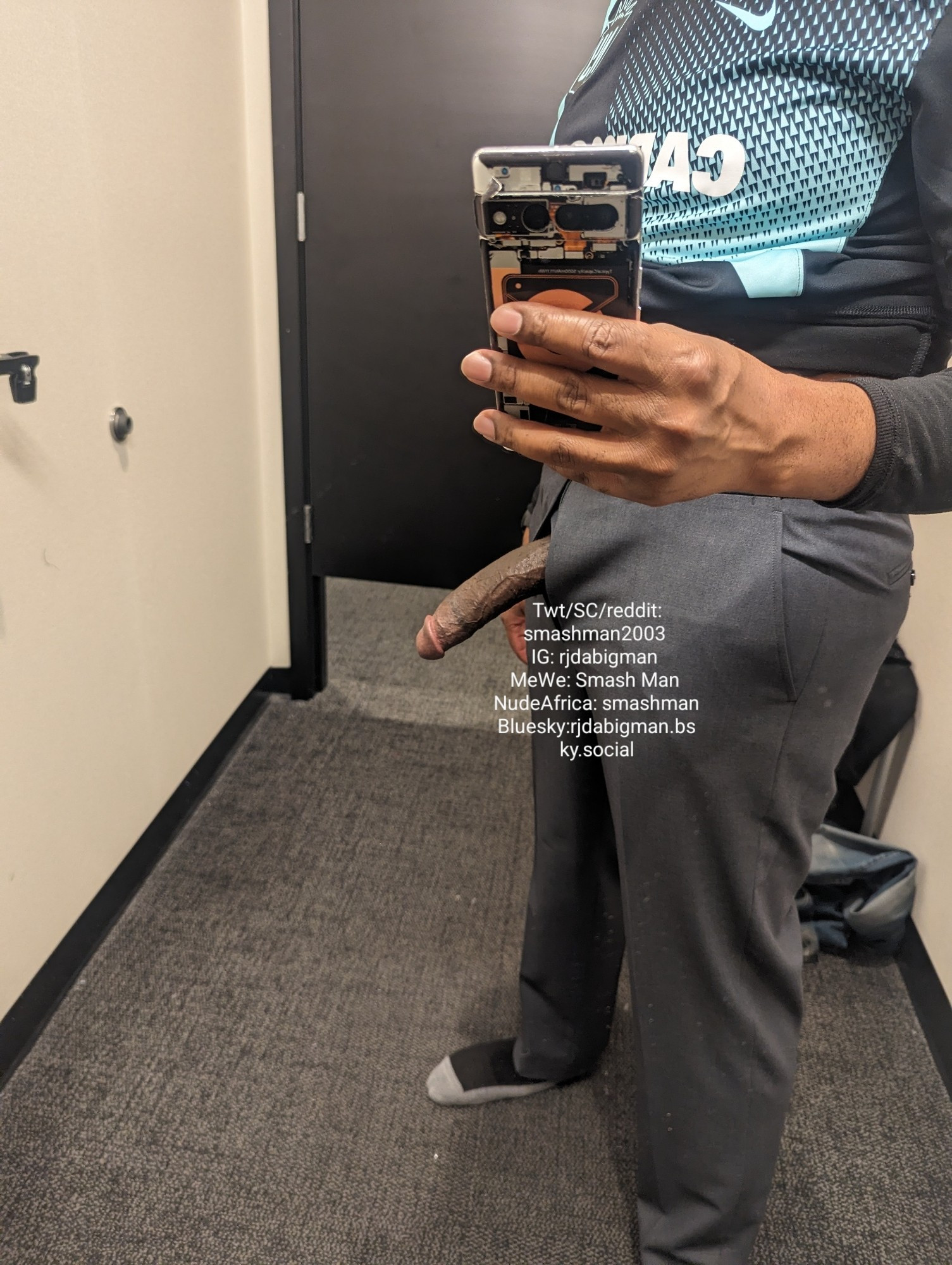 rjdabigman in a dressing room mirror trying on gray dress slacks, with his long, Black, erect dick hanging out of the fly. Side view.