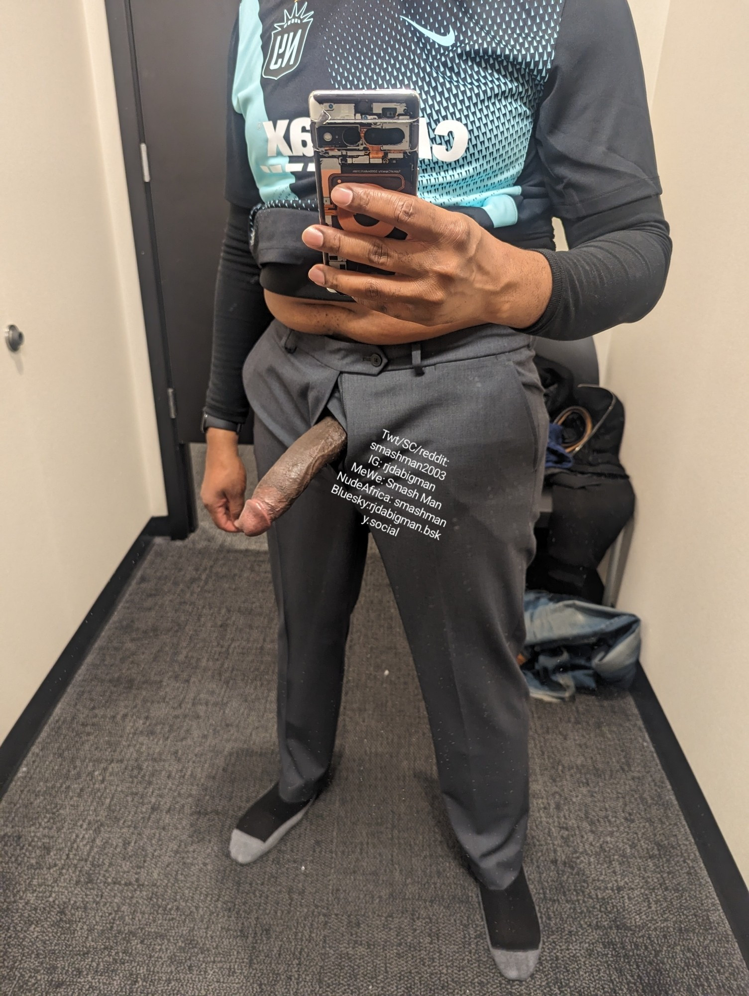 rjdabigman in a dressing room mirror trying on gray dress slacks, with his long, Black, erect dick hanging out of the fly. Front view.