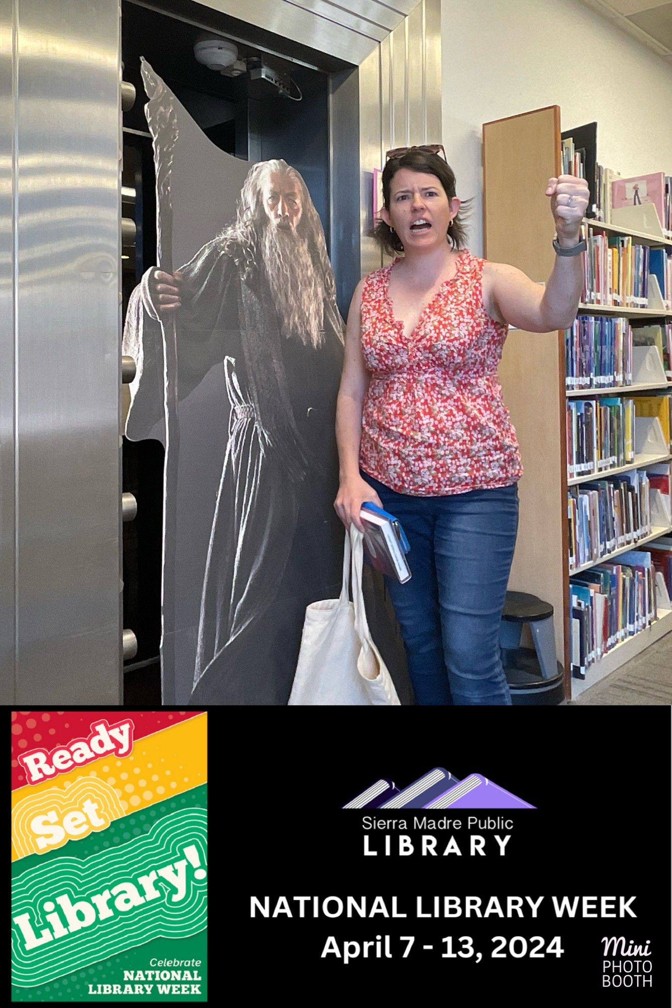 A photo of Jessie raising her fist and making an angry face next to a cardboard life-size cutout of Gandalf also raising his staff and making an angry face. The bottom of the image says "Sierra Madre Public Library" and celebrates National Library Week.