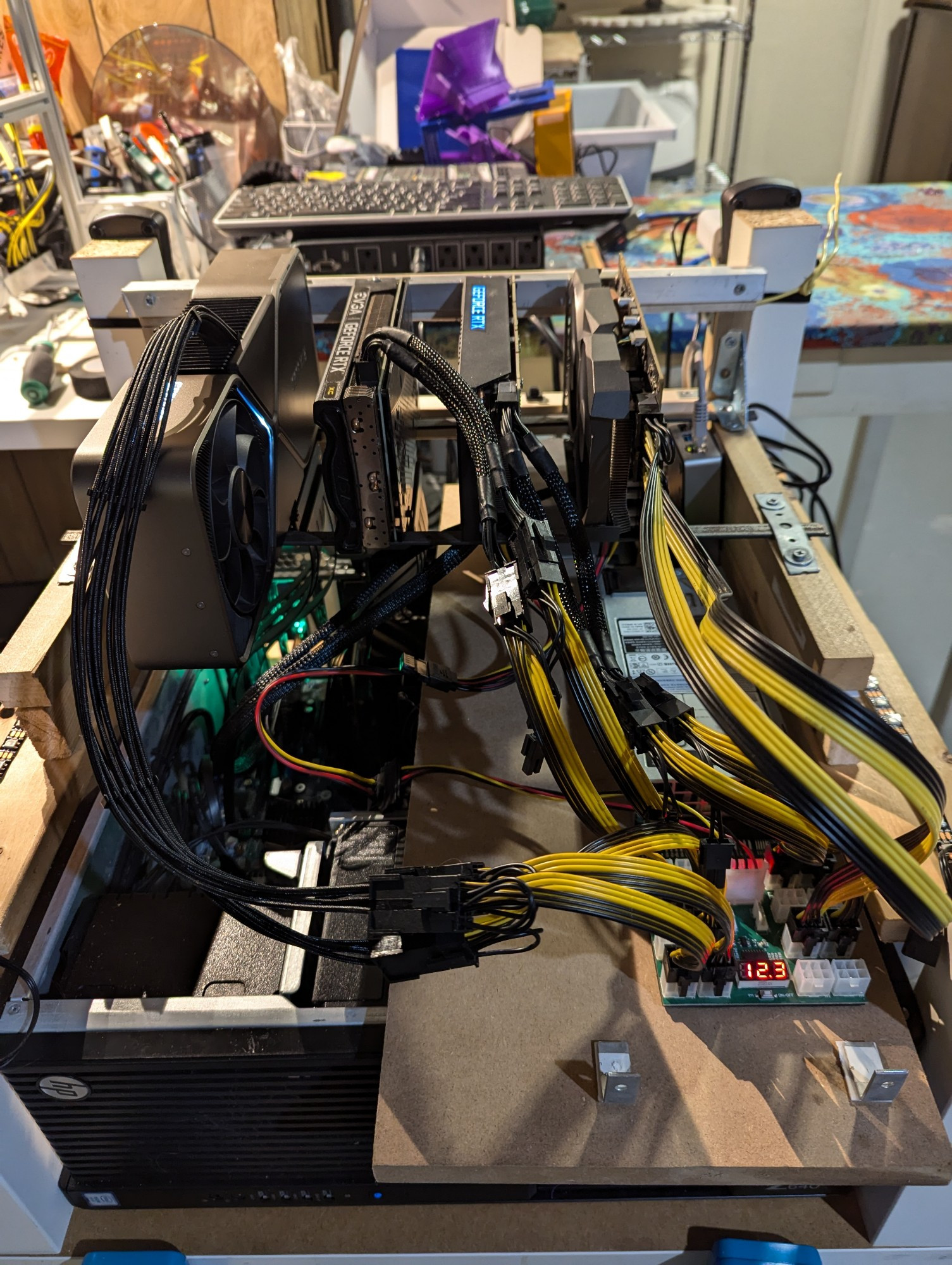 A quad GPU rig with external power, lots of yellow and black cords 