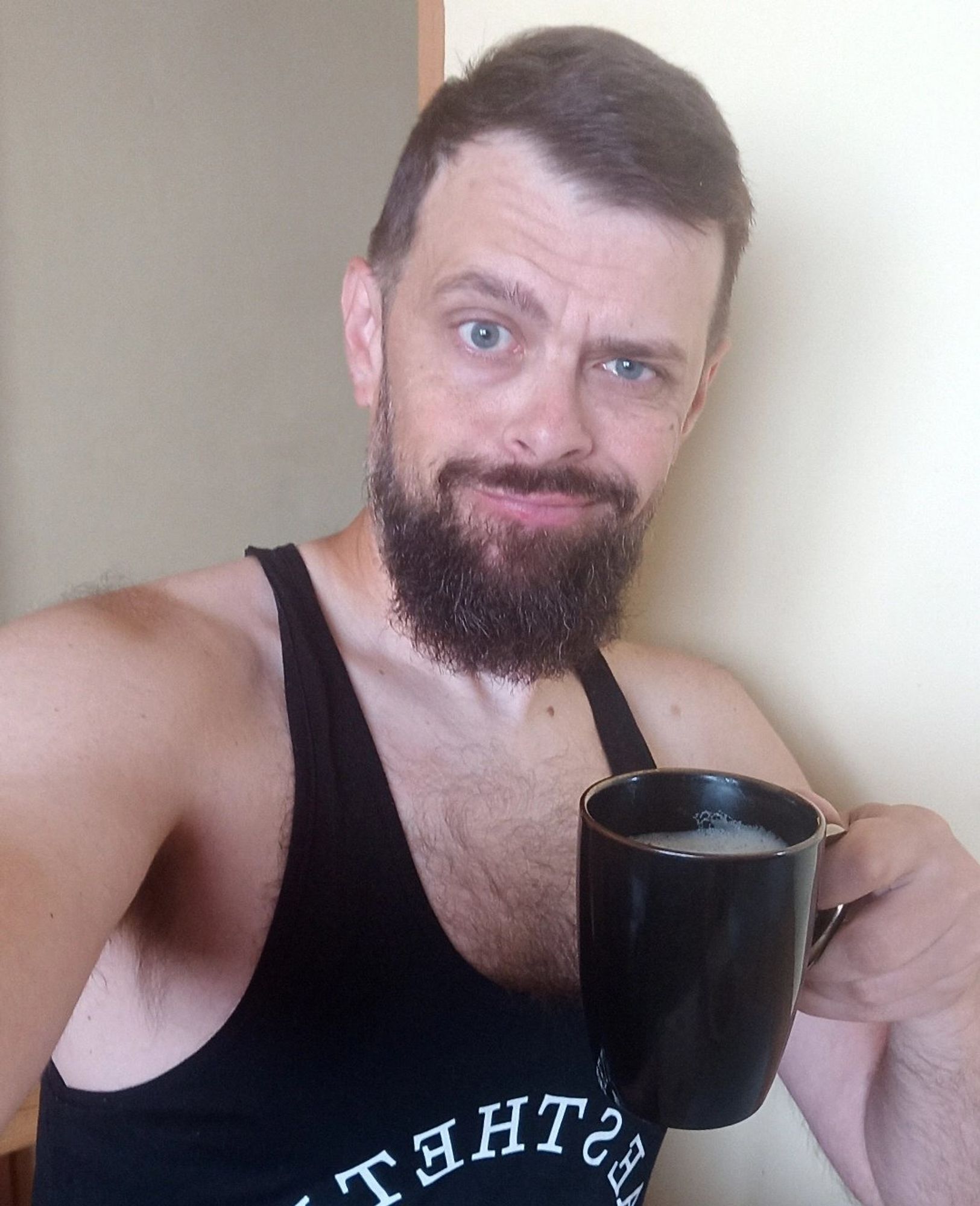 A handsome man with a beard and hairy chest wearing a tank top and holding a cup of hot coffee.
#gay #boy #sexy #bearded #morningwood #polishgay #polishboy #bator #gayselfie