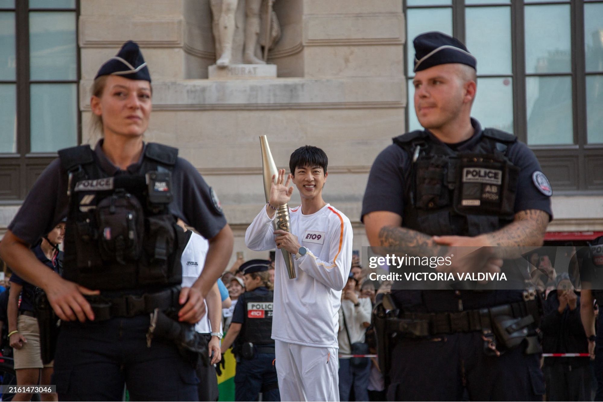 Kim Seokjin Paris Olympics torch bearer smiling and waving