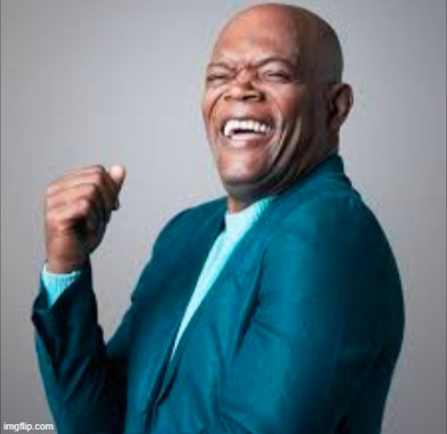 Samuel L Jackson in a blue suit, looking positively giddy with delight