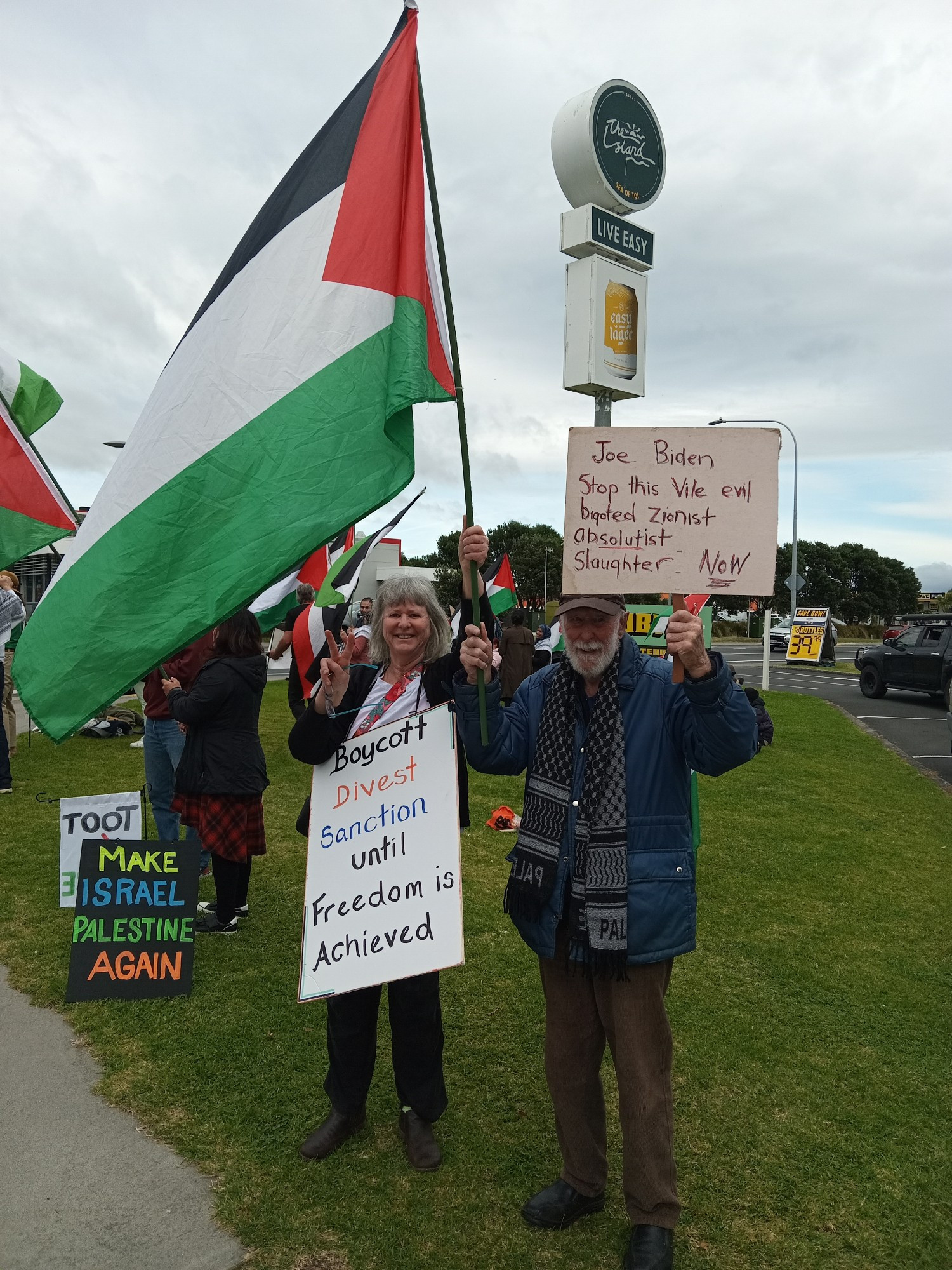 Dad and I. I am holding a Palestinian flag and a placard saying "boycott, divest, sanction until freedom is achieved" and Dad is holding a home made placard telling Biden to stop the zionist slaughter.