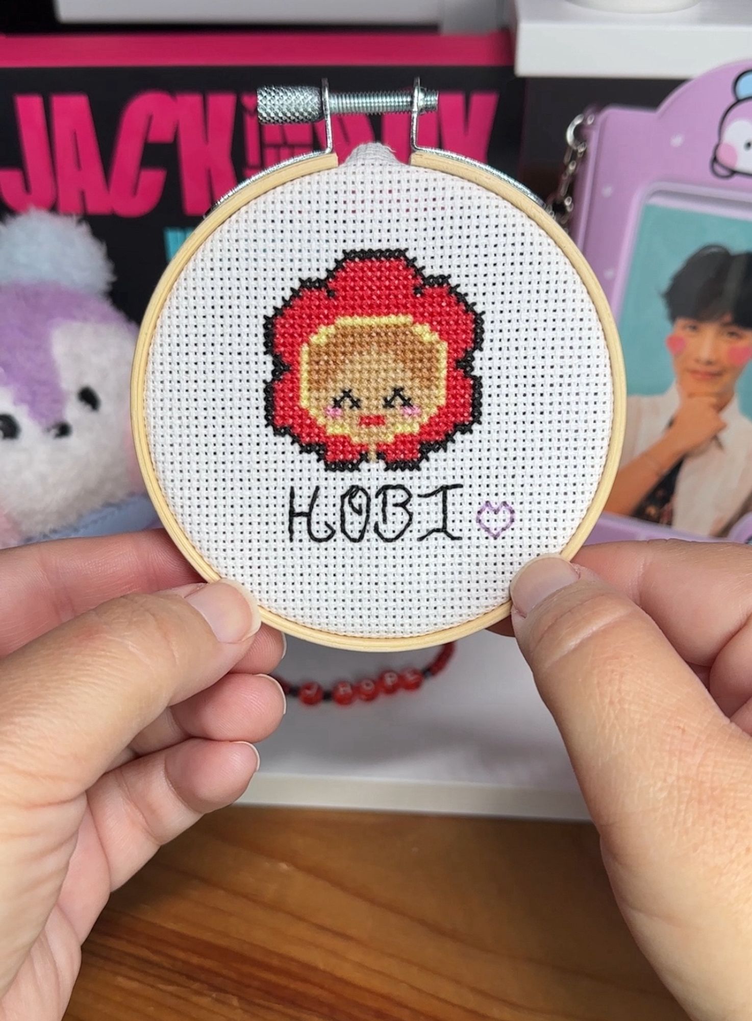 a tiny cross stitch of Hobi wearing a red flower crown