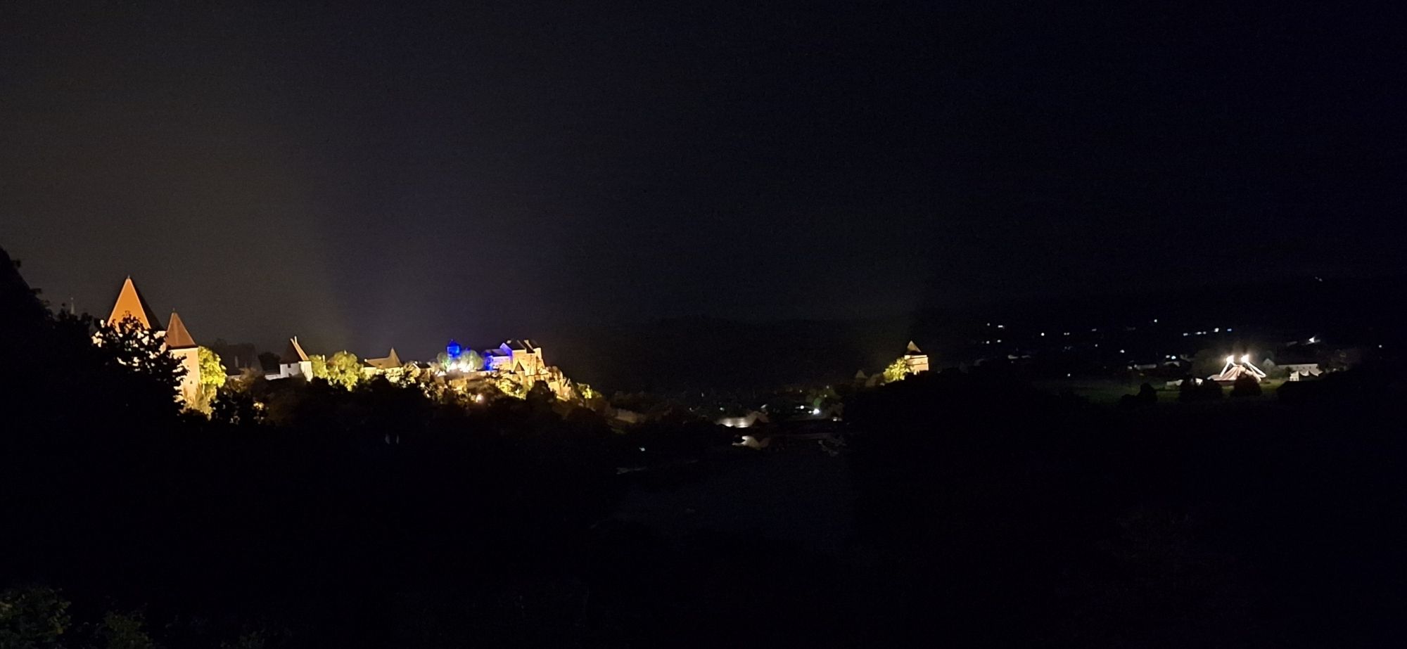 Nachtaufnahme der Burg Burghausen. Zu sehen auch die bunten Lichter einer Musikveranstaltung.