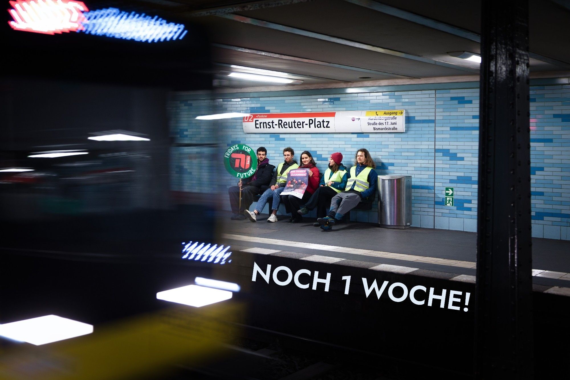 Noch 1 Woche! Foto von einfahrender U-Bahn mit wartenden FFF-Studis auf einer Bank