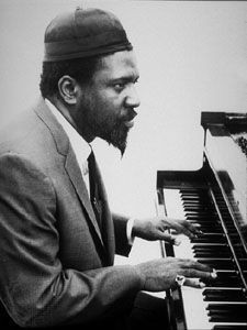 Black and white photo of Thelonious Monk sitting at the piano.