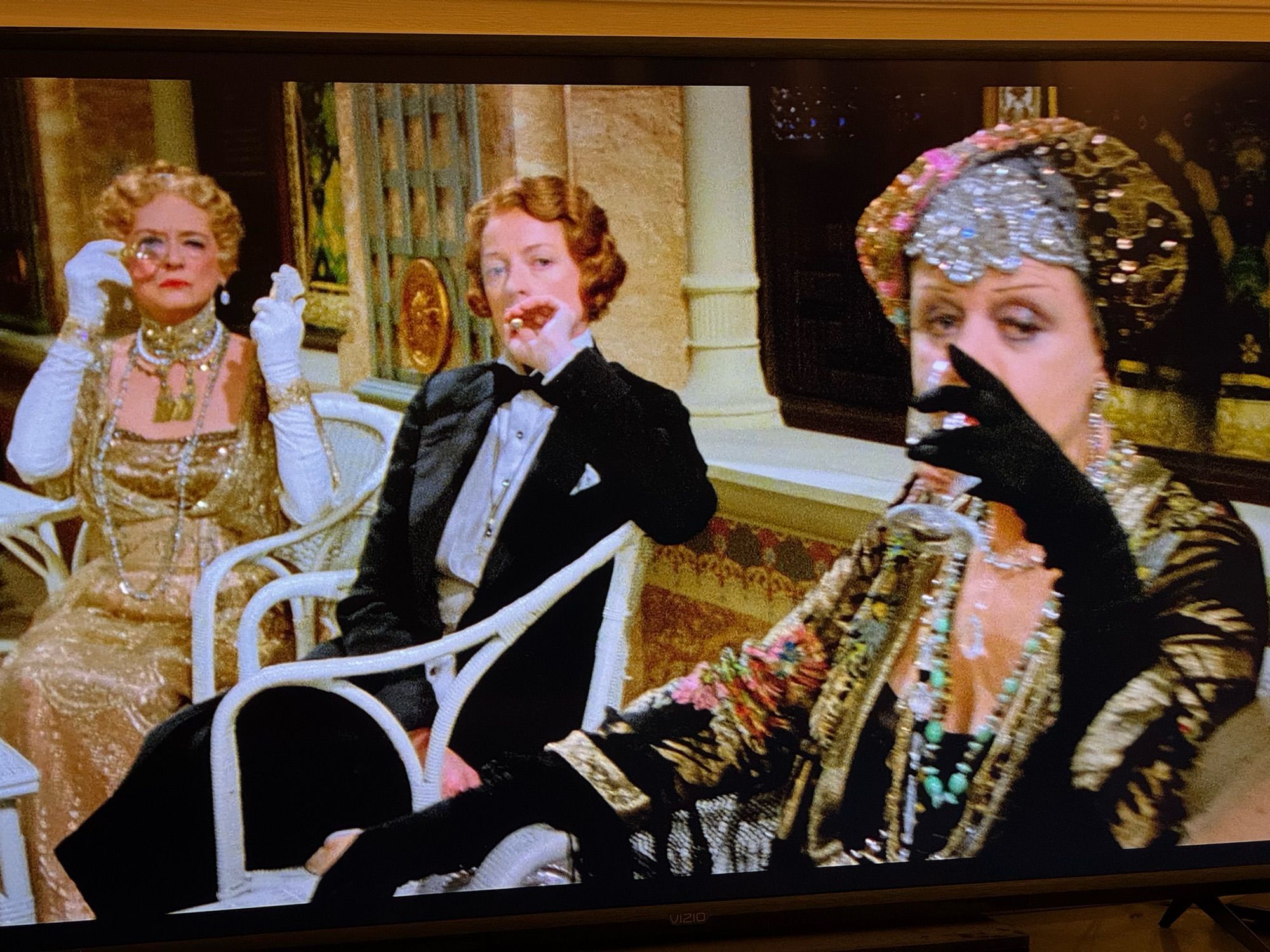 Bette Davis in a gold ‘rich old widow’ dress with arm length white gloves and a monocle, Maggie Smith in that tux smoking and giving “yeah fuck you” and Angela Lansbury sipping her drink while wearing this crazy over the top thing I just can’t describe. Genius.