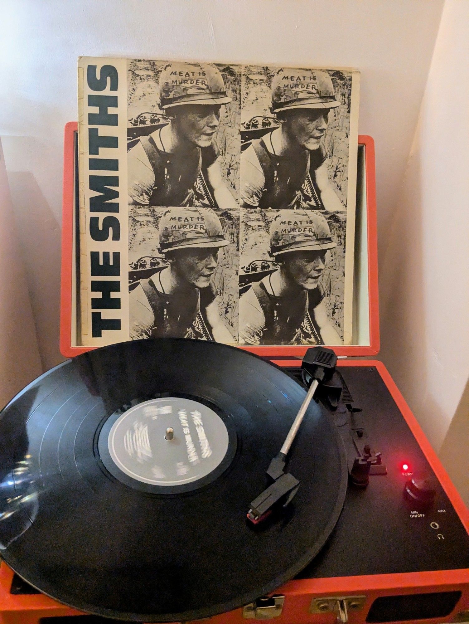 The Smiths meat is murder album on an orange and black record player.