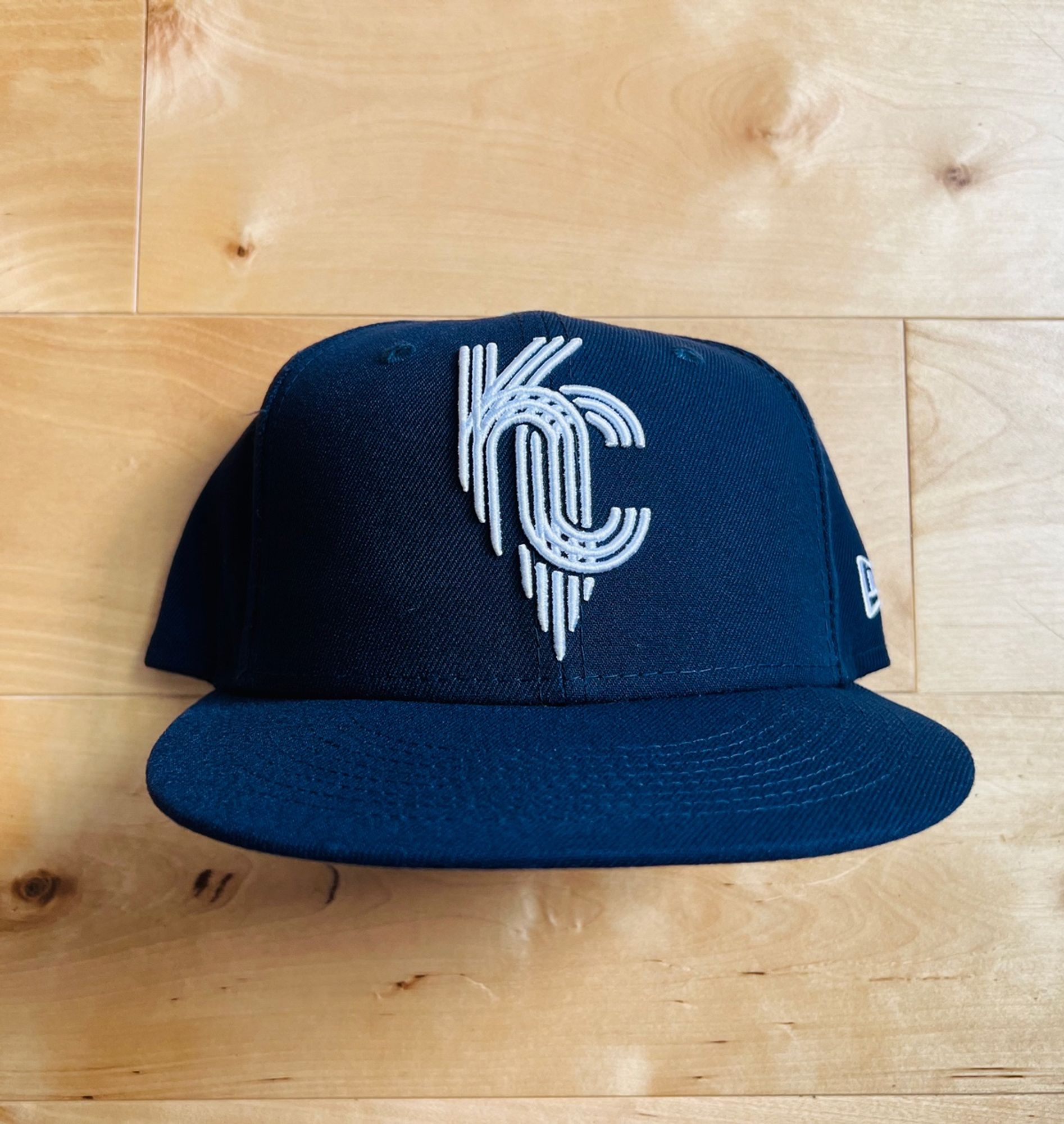 The Kansas City Royals City Connect hat. The crown and visor are both navy, and you can't see it but there's a light blue button. The white "KC" logo is different from their traditional monogram. It's based on the city emblem, which is itself based on fountains. There are a lot of fountains in Kansas City.