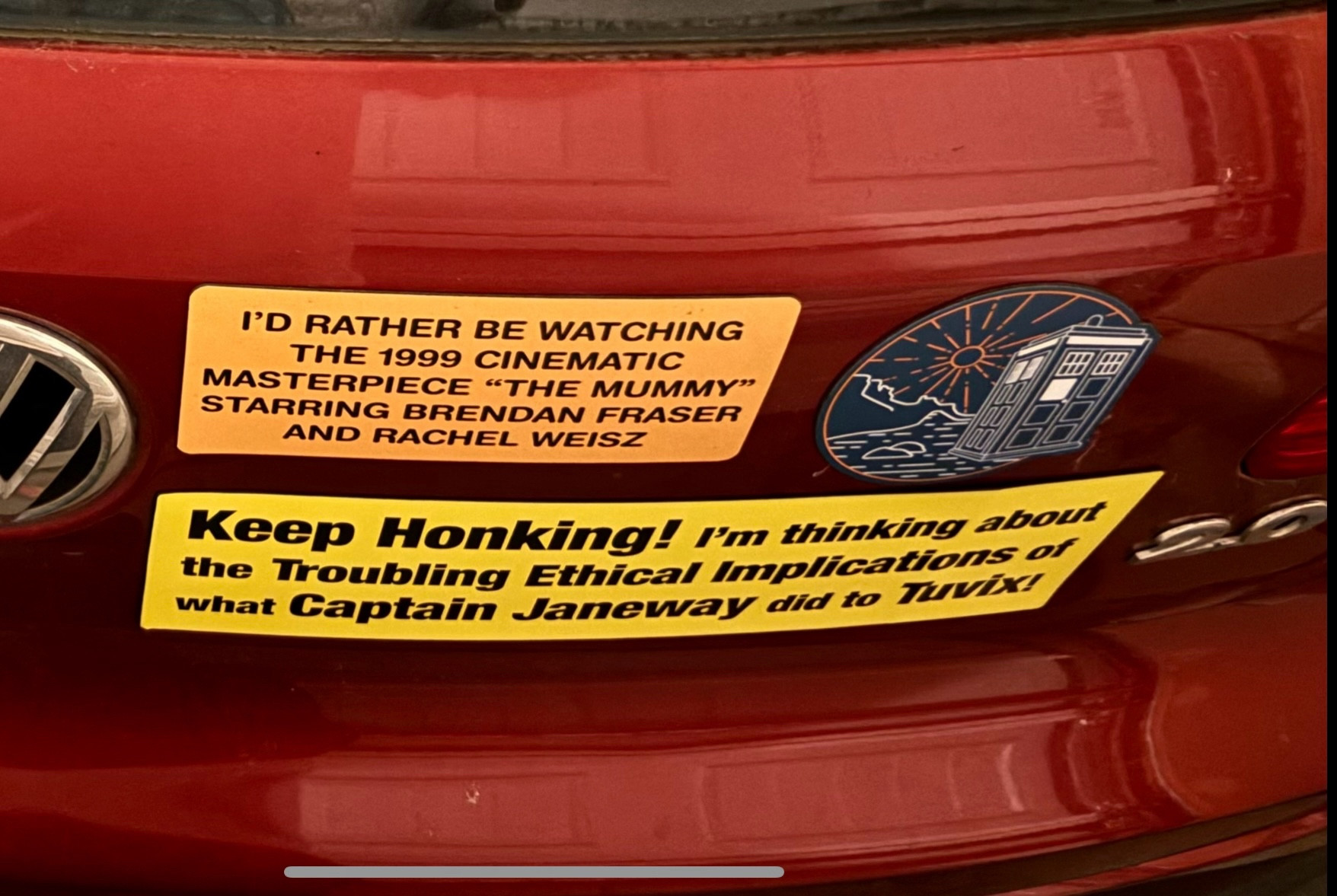 Bumper stickers read: “I’d rather be watching the 1999 cinematic masterpiece ‘The Mummy’ Starring Brendan Fraser and Rachel Weisz” and another (newly added) that reads: “Keep Honking! I’m thinking about the troubling ethical implications of what Captain Janeway did to Tuvix!” - first one from Etsy, second one from podshop.biz, run by the greatest comedy duo in podcasting.