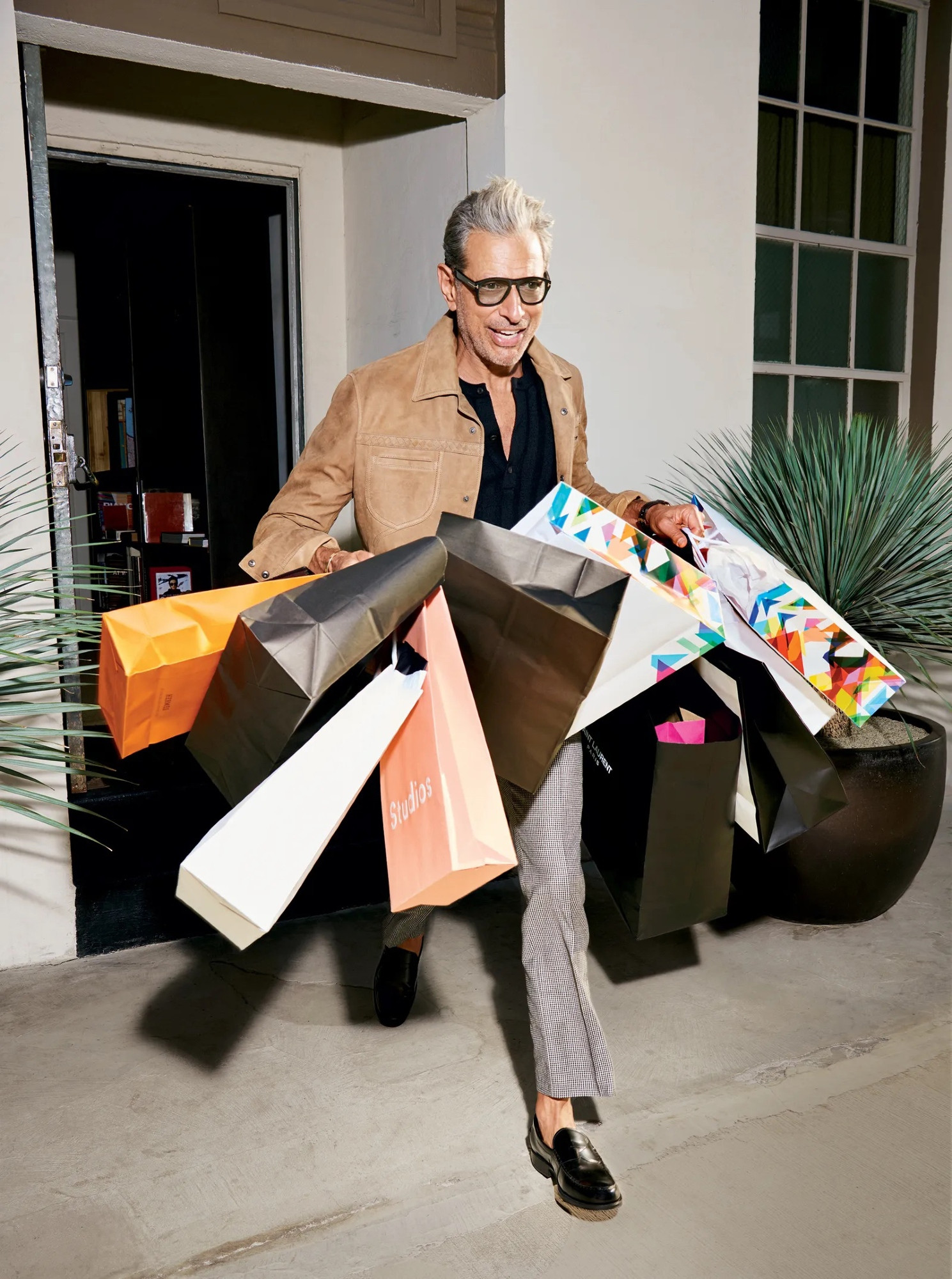 Jeff Goldblum running out of a store carrying a bunch of shopping bags