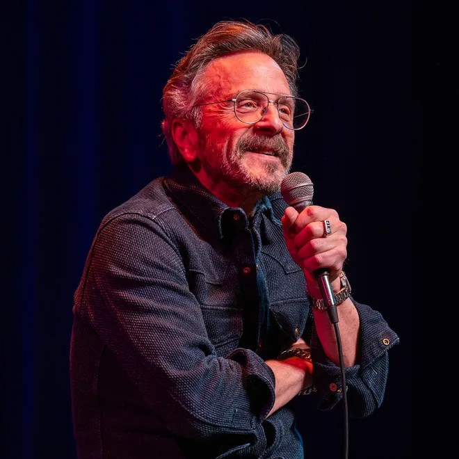 Marc Maron on stage wearing a blue Western shirt from Ship John. The shirt is made from a textured Japanese fabric called sashiko. 
