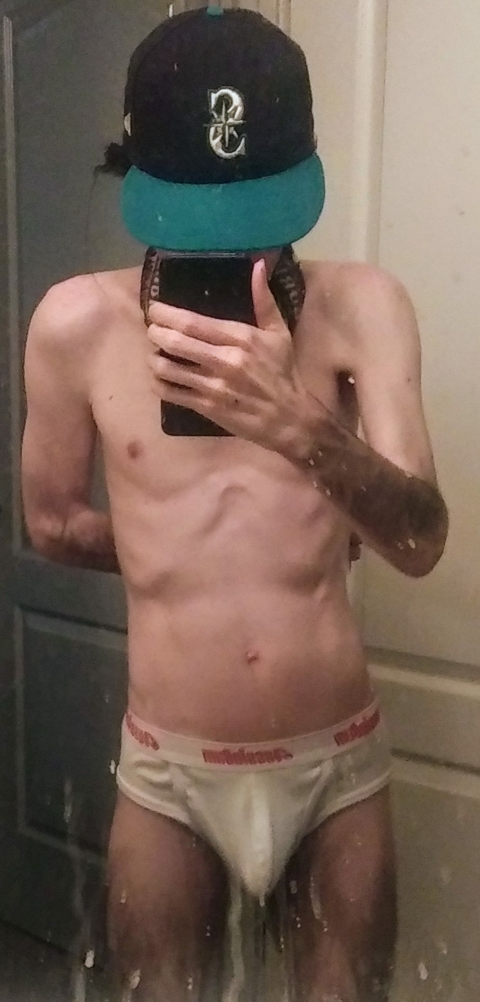 mirror selfie of a man in aussieBum white briefs, face covered by phone and ballcap