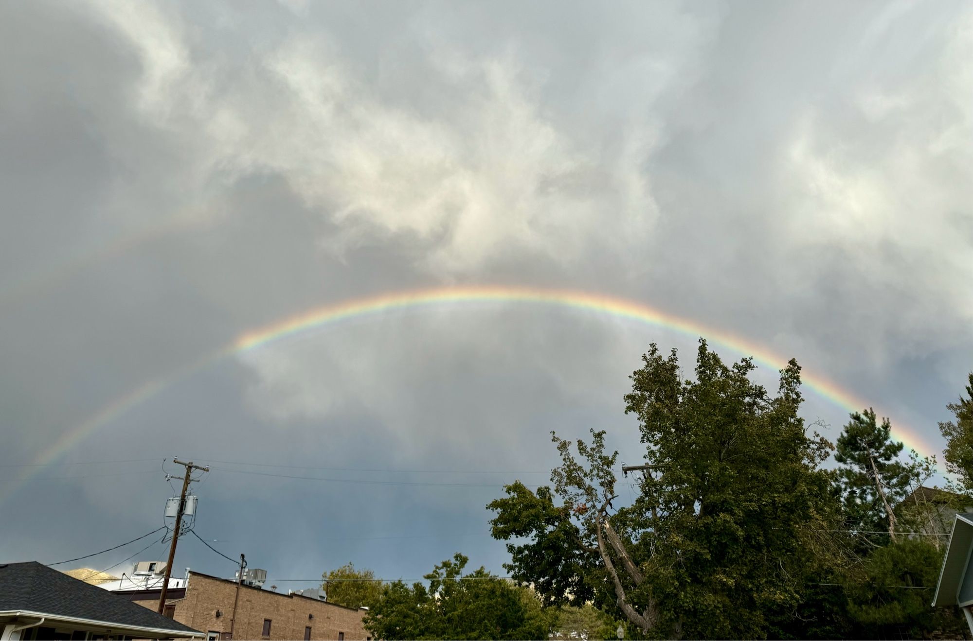 Double rainbow in the rainy sky with clouds over Salt Lake City.