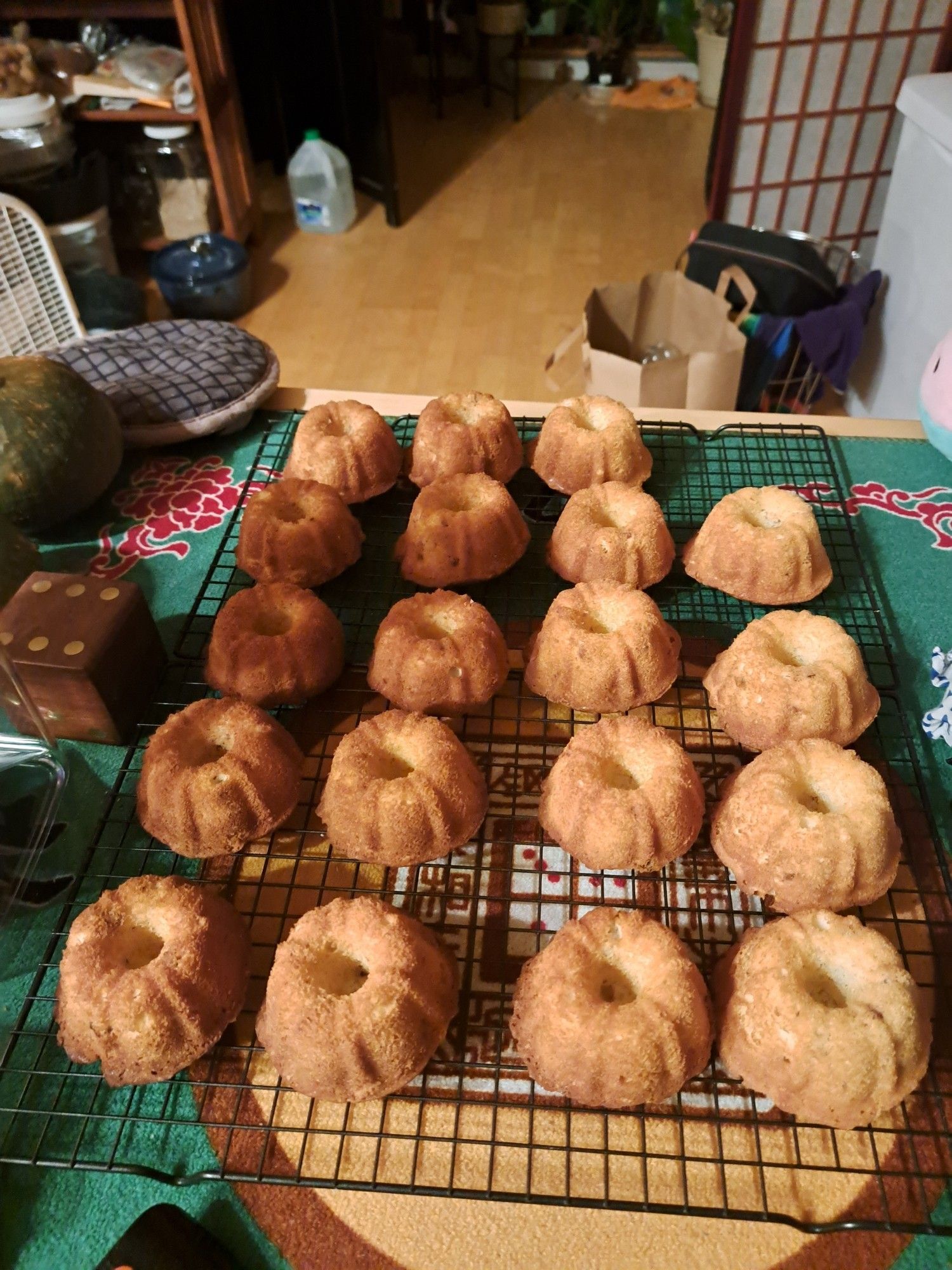 A set of twenty (minus one) mini bundt cakes set out on a cooling rack.