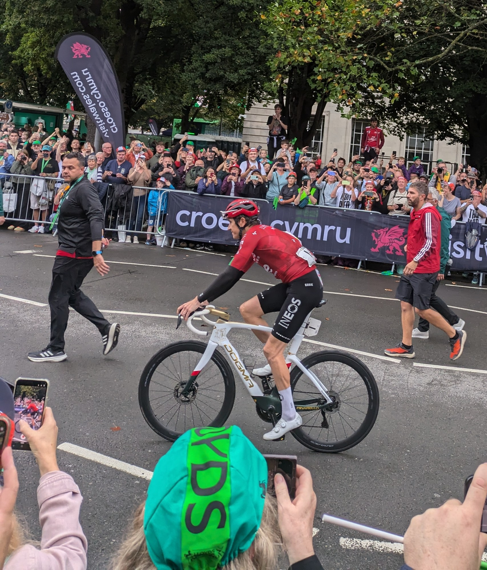 Geraint on bike near race finish line, heading left, with crowds on each side of the road 