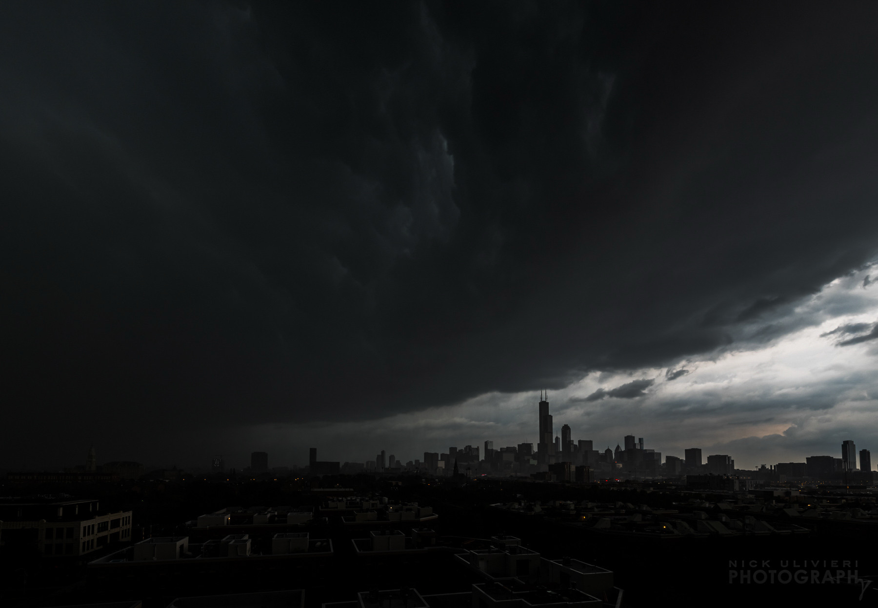 A very moody scene of an intense thunderstorm moving through Chicago. The skyline is small and distant while a massive, dark shelf cloud takes over the sky. This is from a derecho that plowed across the Midwest on August 10, 2020