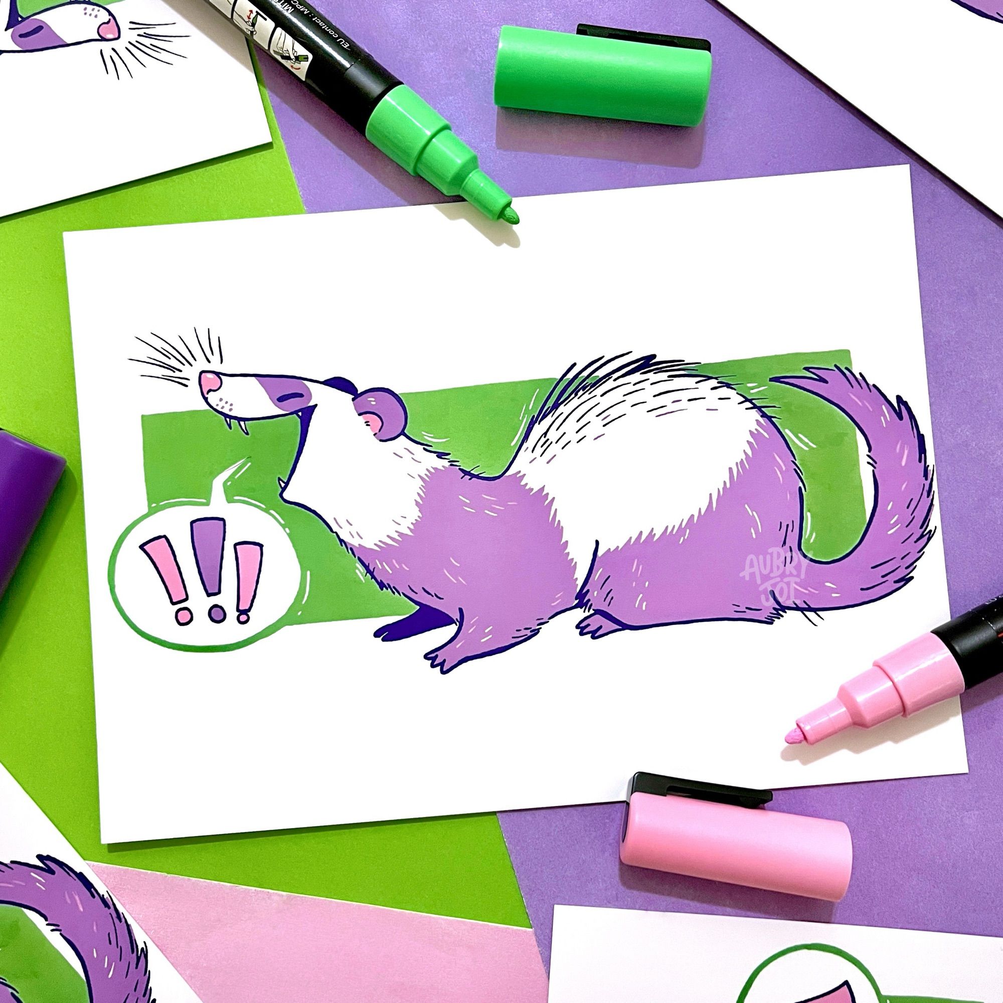 An art print of a purple & white ferret with a wide open mouth, a speech bubble coming from it with “!!!” inside. The ferret is on top of a slim green rectangle background. The art print has a few Posca pens laying around it.