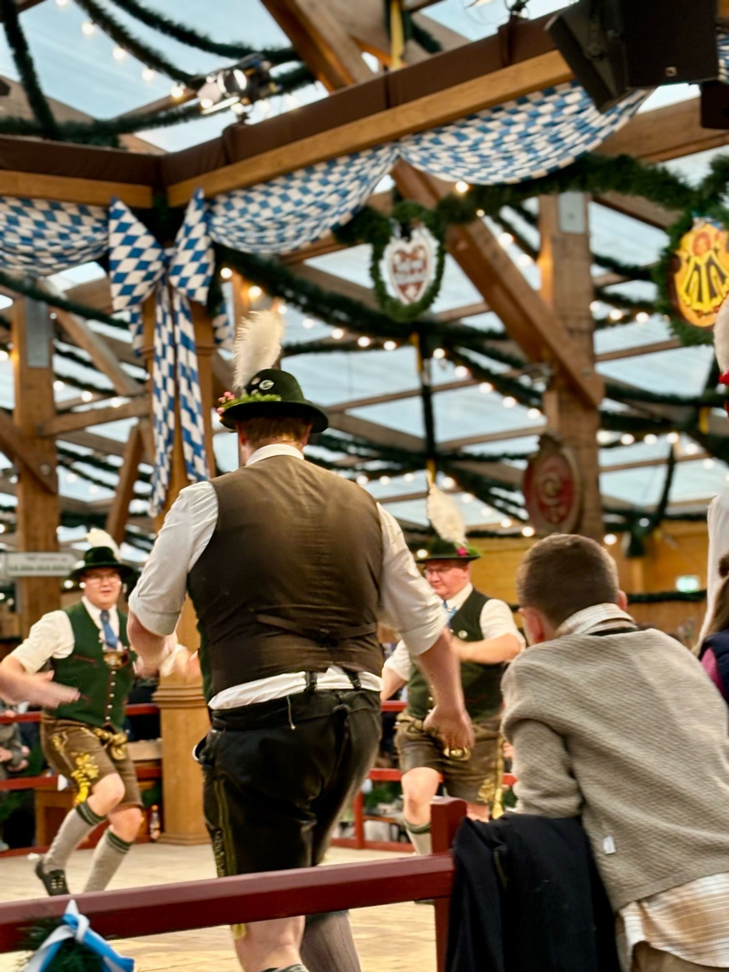 Bavarians doing a traditional dance. They are wearing marvellous hats with feathers in them