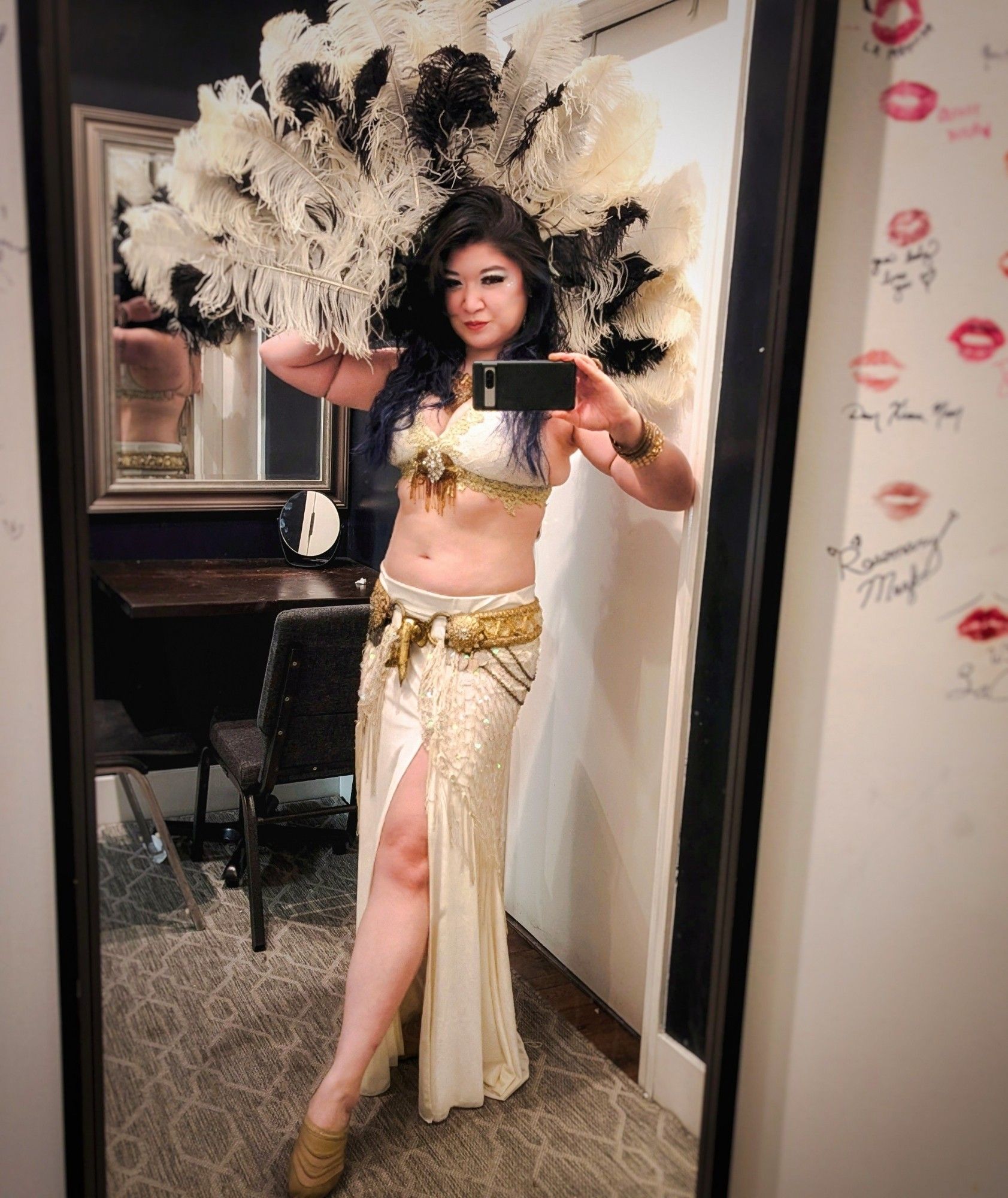 Asian American fusion bellydancer backstage with a feather fan