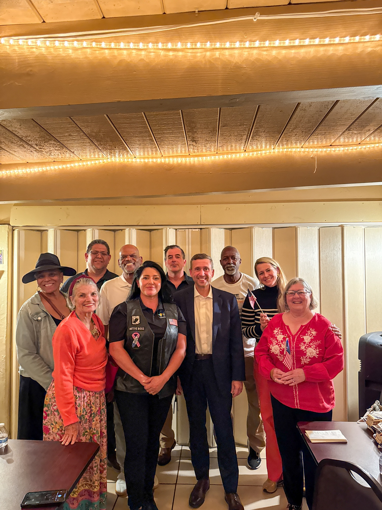 DNC Chair Ken Martin posing for a group photo with veterans at the Vista American Legion in Vista, CA