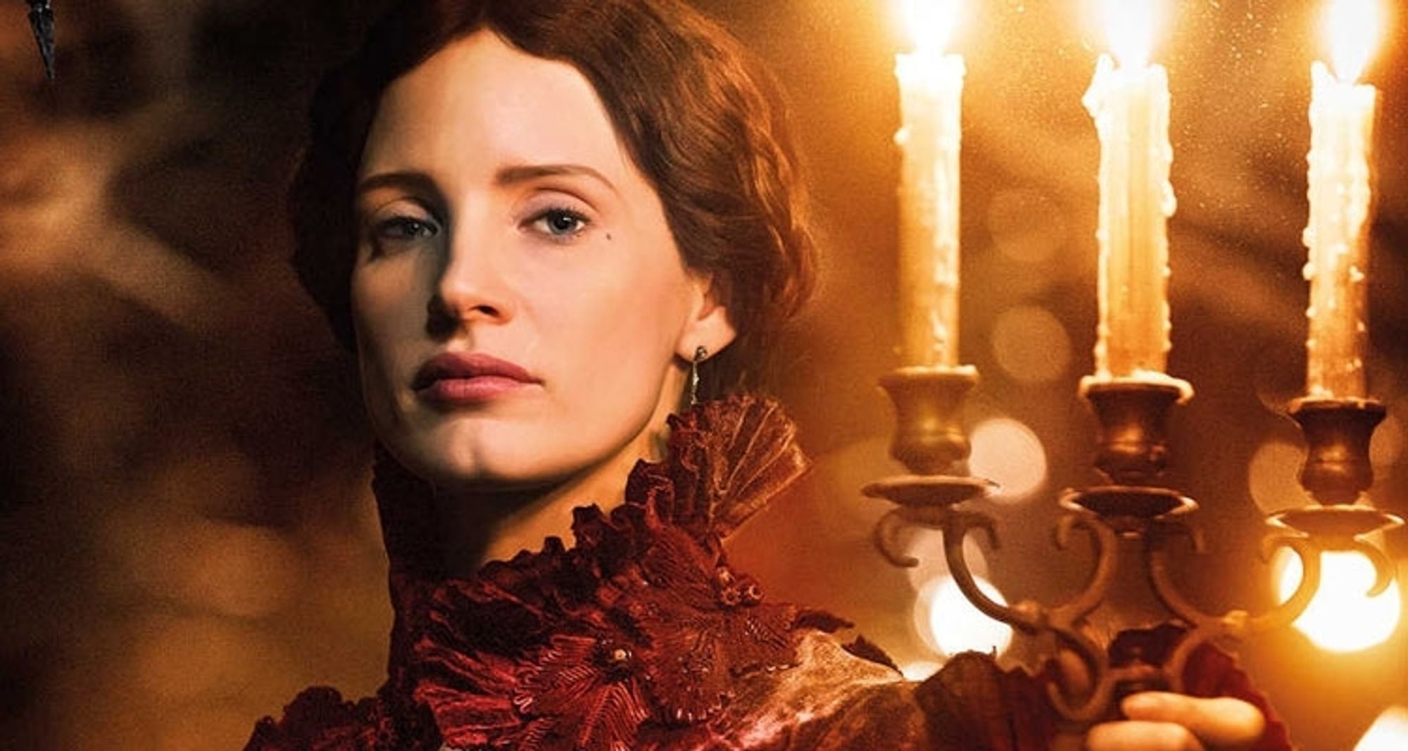 Jessica Chastain as Lady Lucille in Crimson Peak, wearing an old fashioned formal dress and holding a lit candlestick