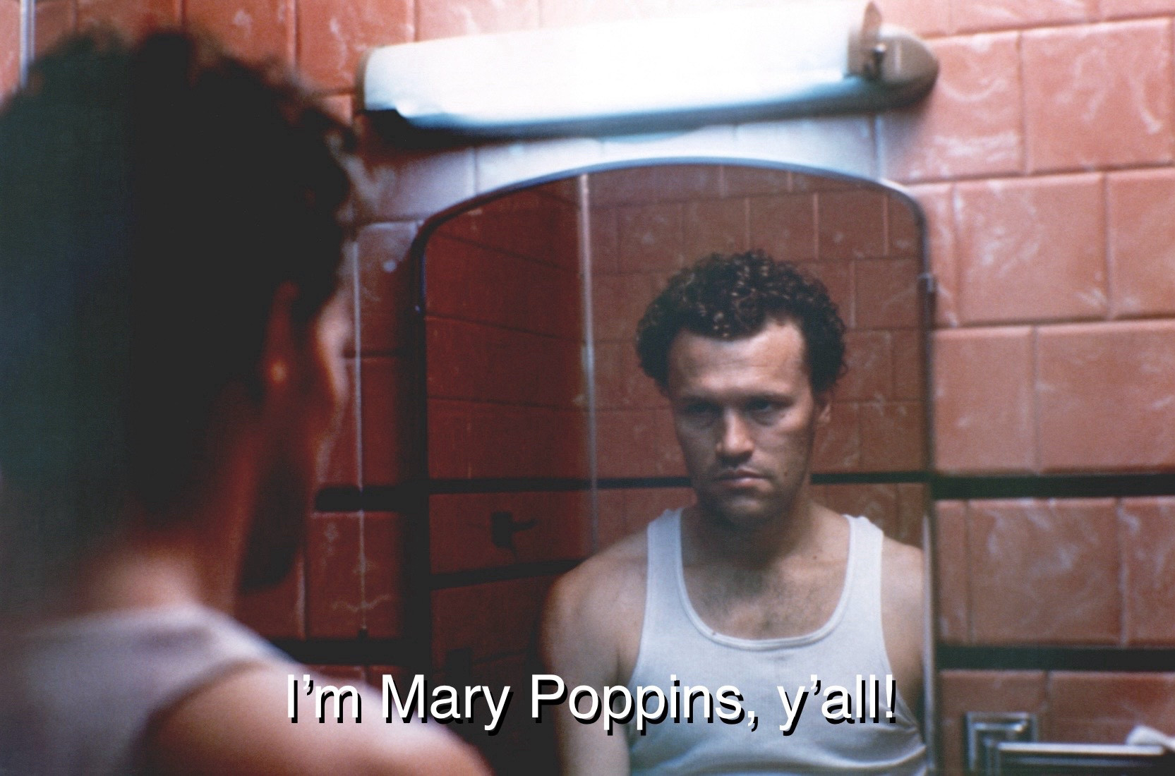 Still image from Henry: Portrait of a Serial Killer in which Henry (Michael Rooker) stares grimly at his reflection in the mirror, with a subtitle reading “I’m Mary Poppins, y’all!”