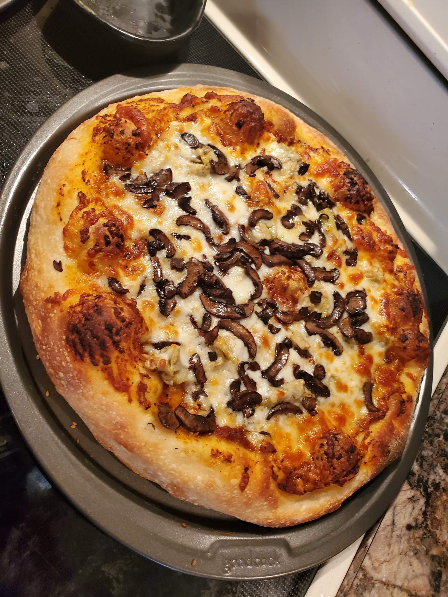 Mushroom and artichoke pizza with goat mozzarella and a smoked red and hatch pepper sauce.