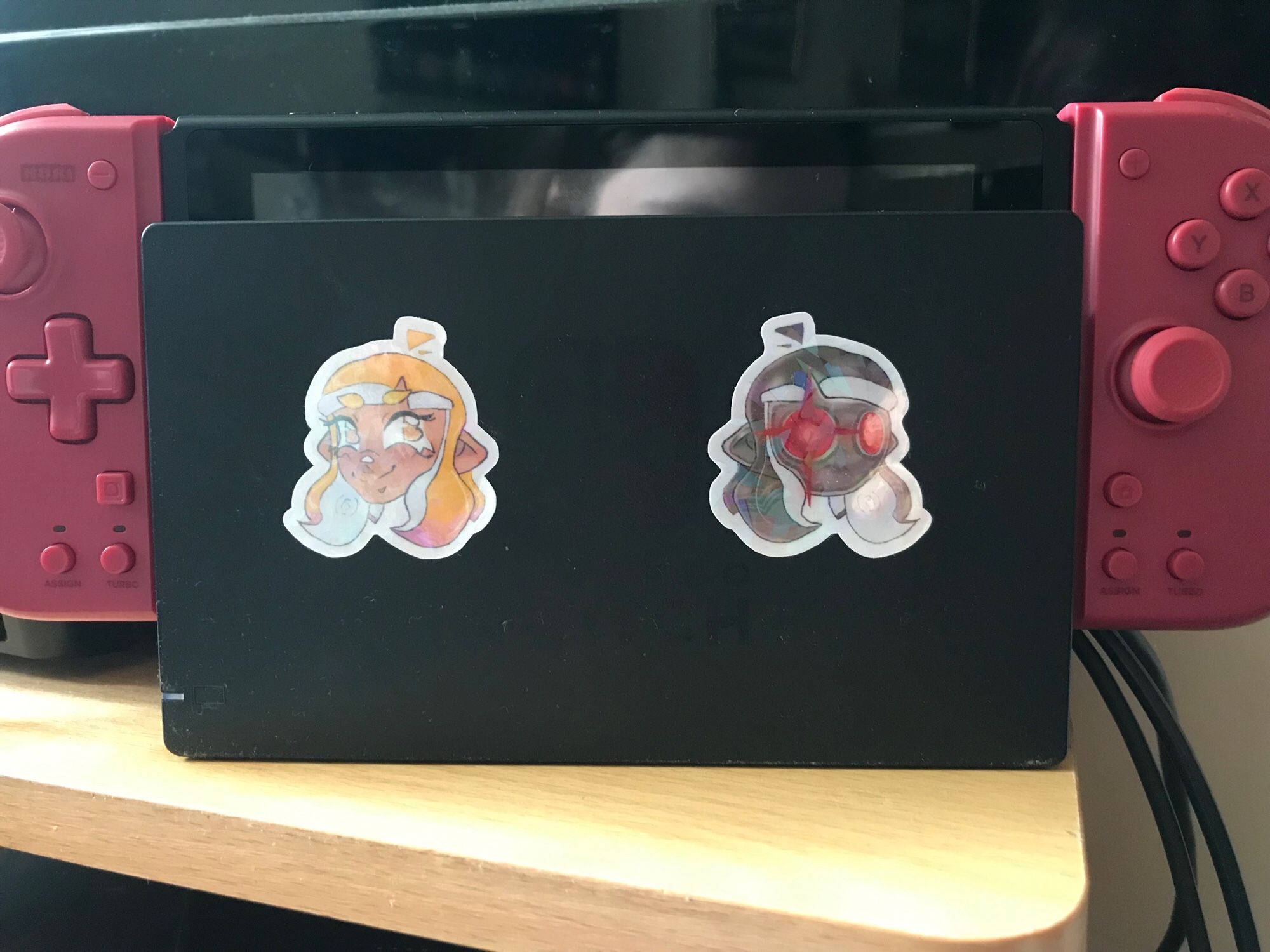 The side of a Nintendo Switch dock, where the Agent 4 and Parallel Canon have been placed on either side of the console’s logo.