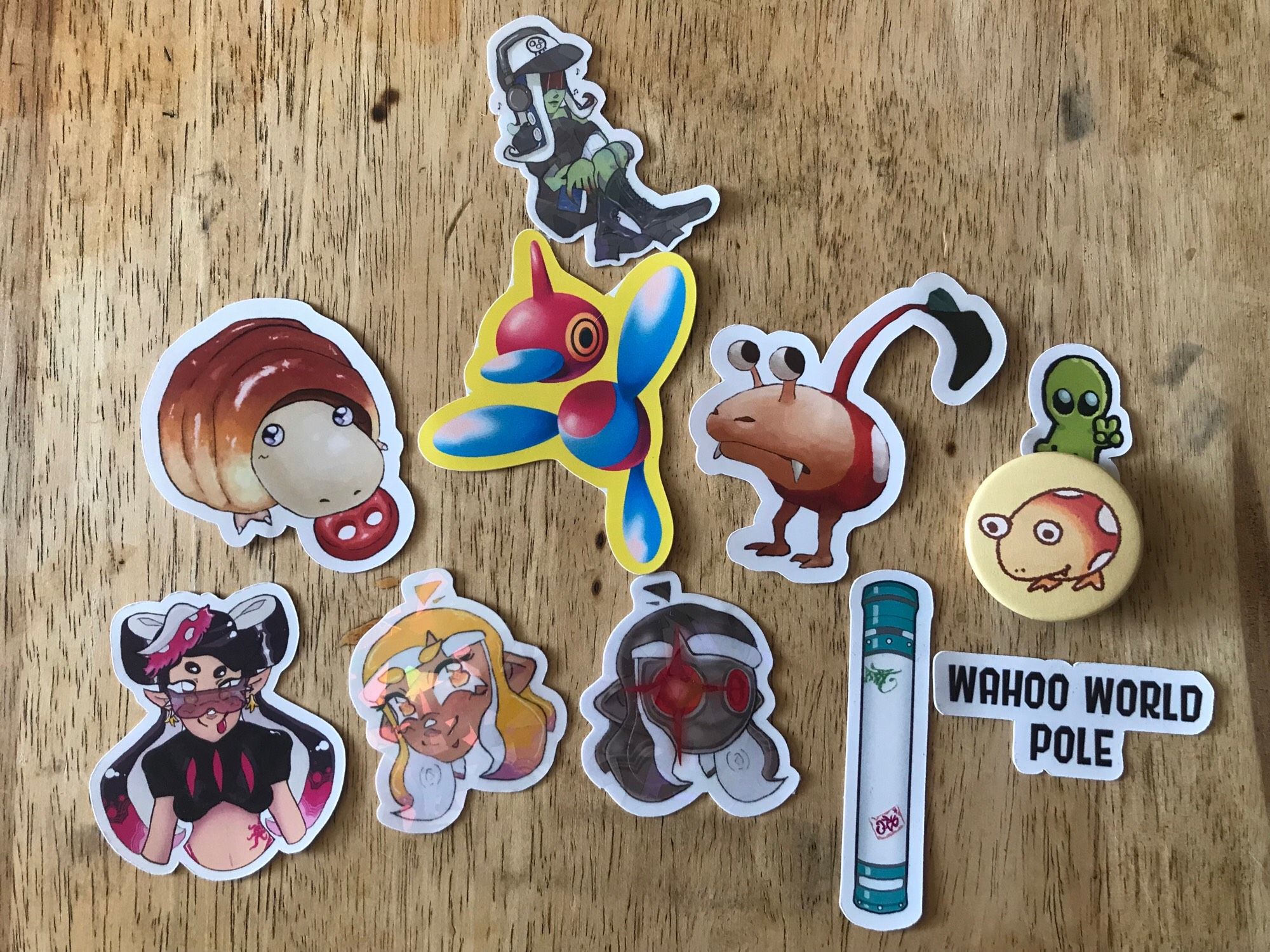 Stickers of Acht, Agent 4, Parallel Canon,  Callie and the Wahoo World pole from the Splatoon series, stickers of a Breadbug and Bulbmin and a pinbadge of a Bulborb from the Pikmin series, a sticker of the Pokémon Porygon-Z, and a small alien sticker.