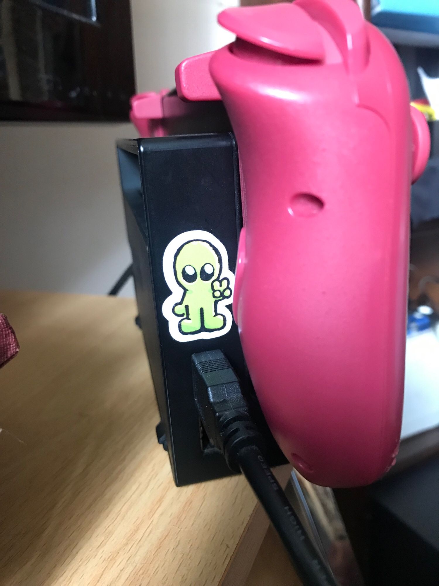 The front of the Nintendo Switch dock, where the small alien sticker has been placed.