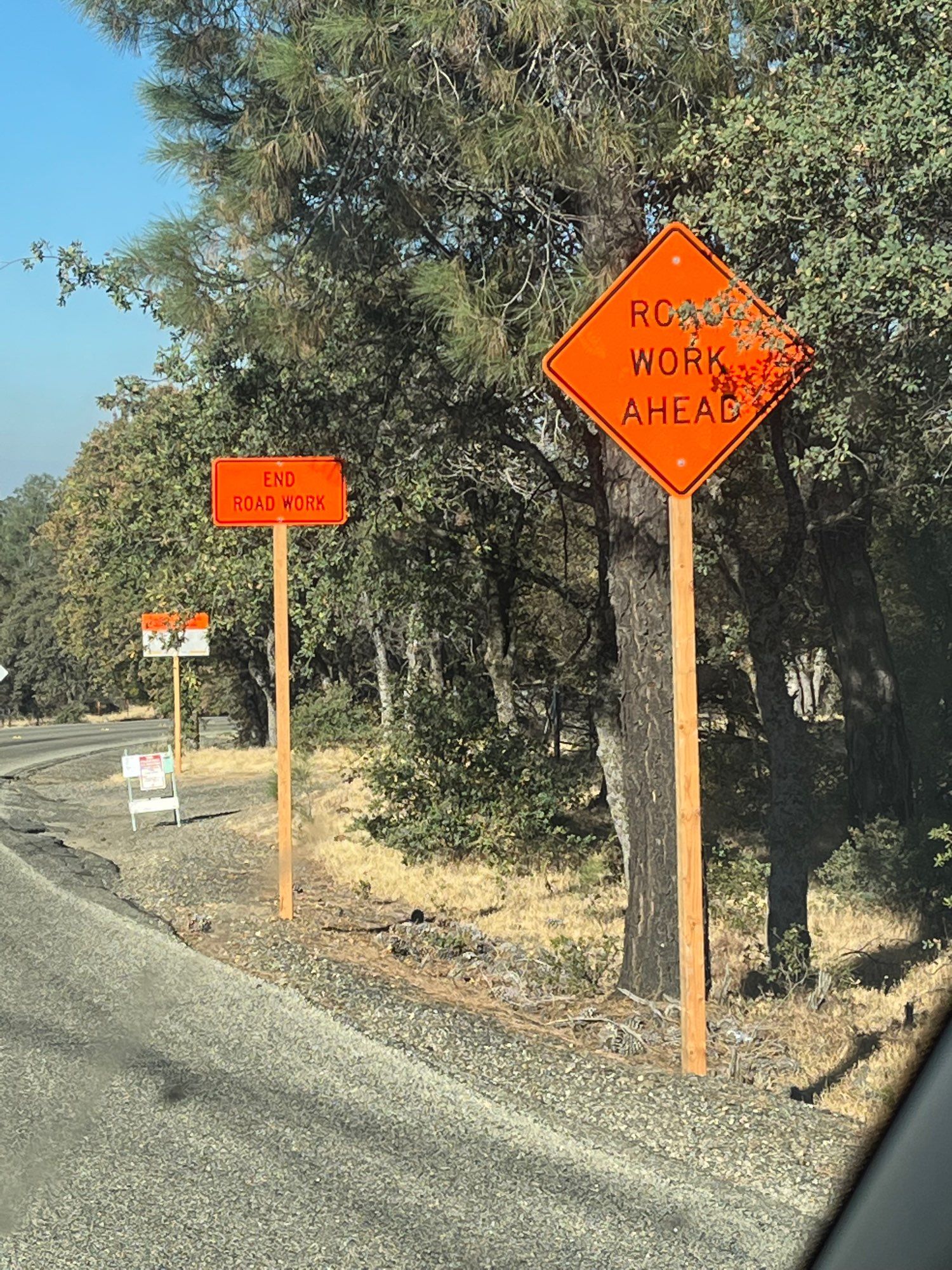 Two signs six feet from each other—road work ahead and end road work. 