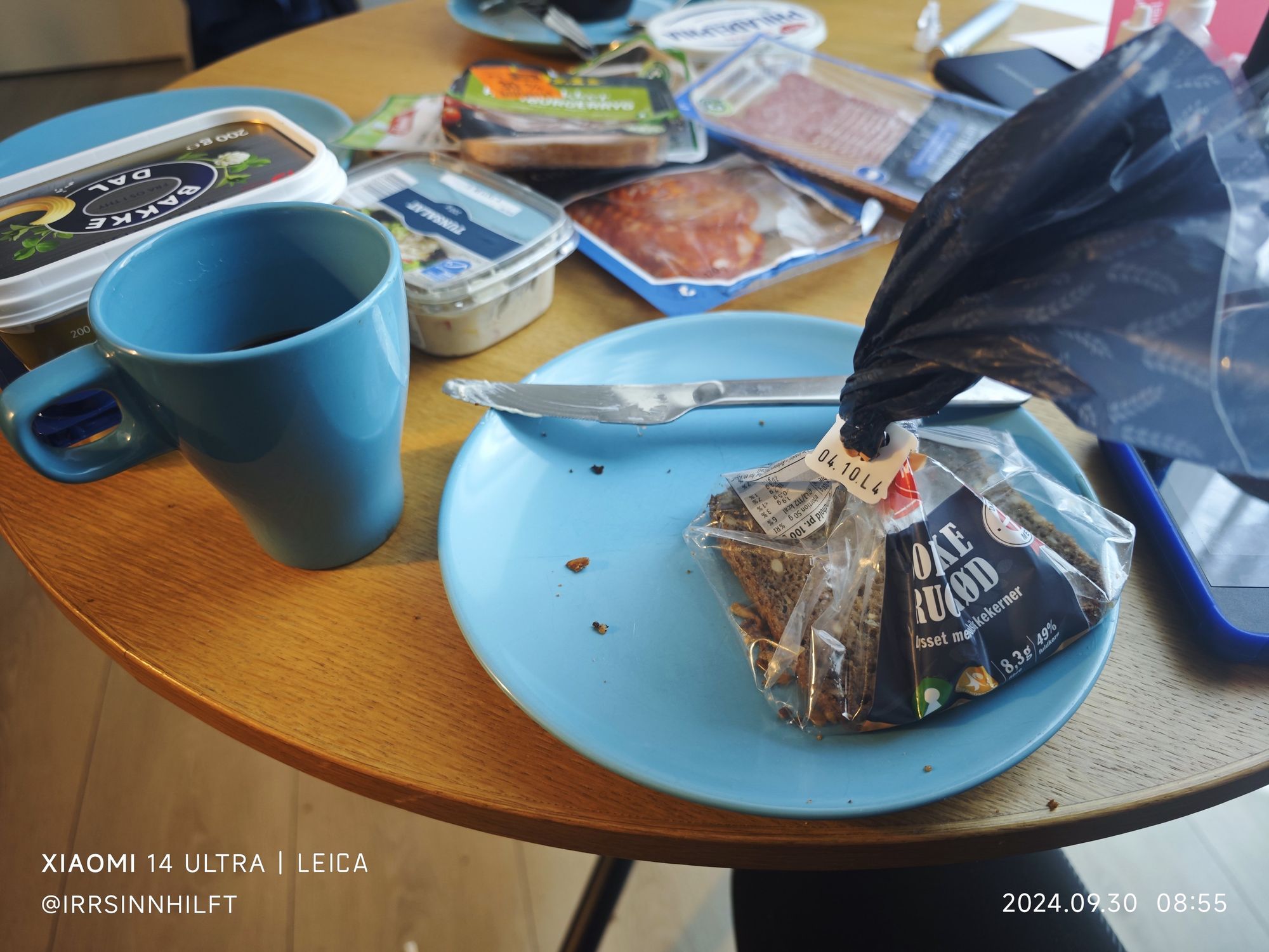 Blauer Teller und eine blaue Tasse, Eine Packung dänisches Roggenbrot (fast alle).
Butter, Wurst und Käse in Packungen, die die ganze Woche reichen werden.