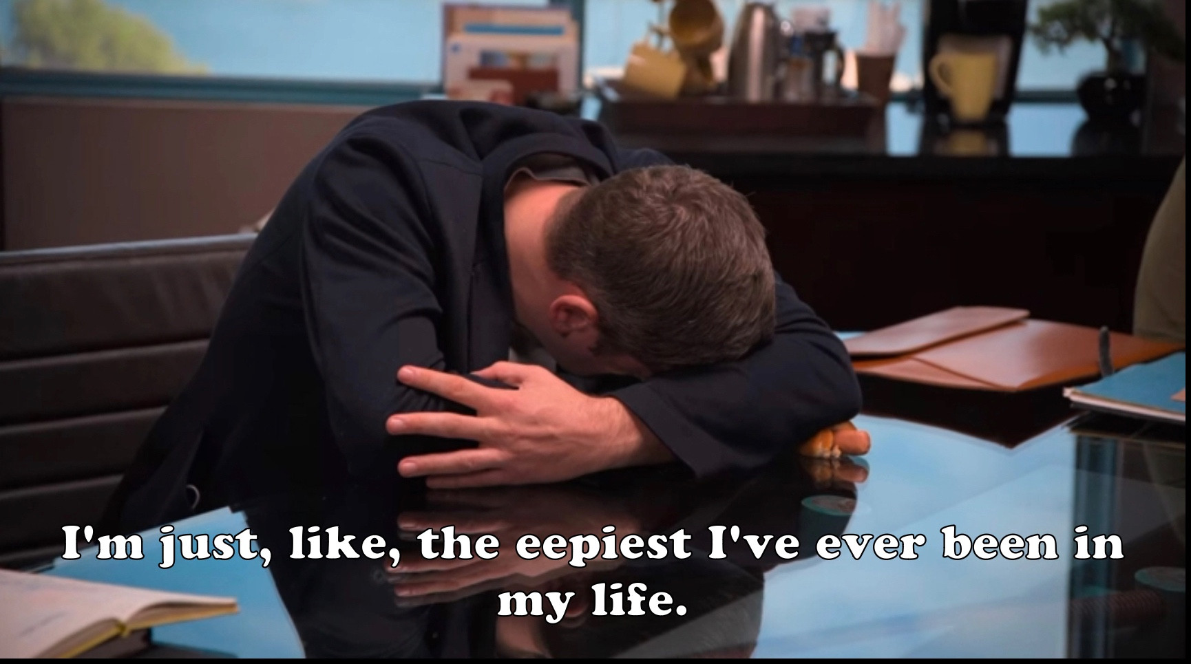 Tim Robinson from I Think You Should Leave with his head down in his crossed arms on the table. There is a hotdog under his left elbow. The image is captioned “I’m just, like, the eepiest I’ve ever been in my life.”