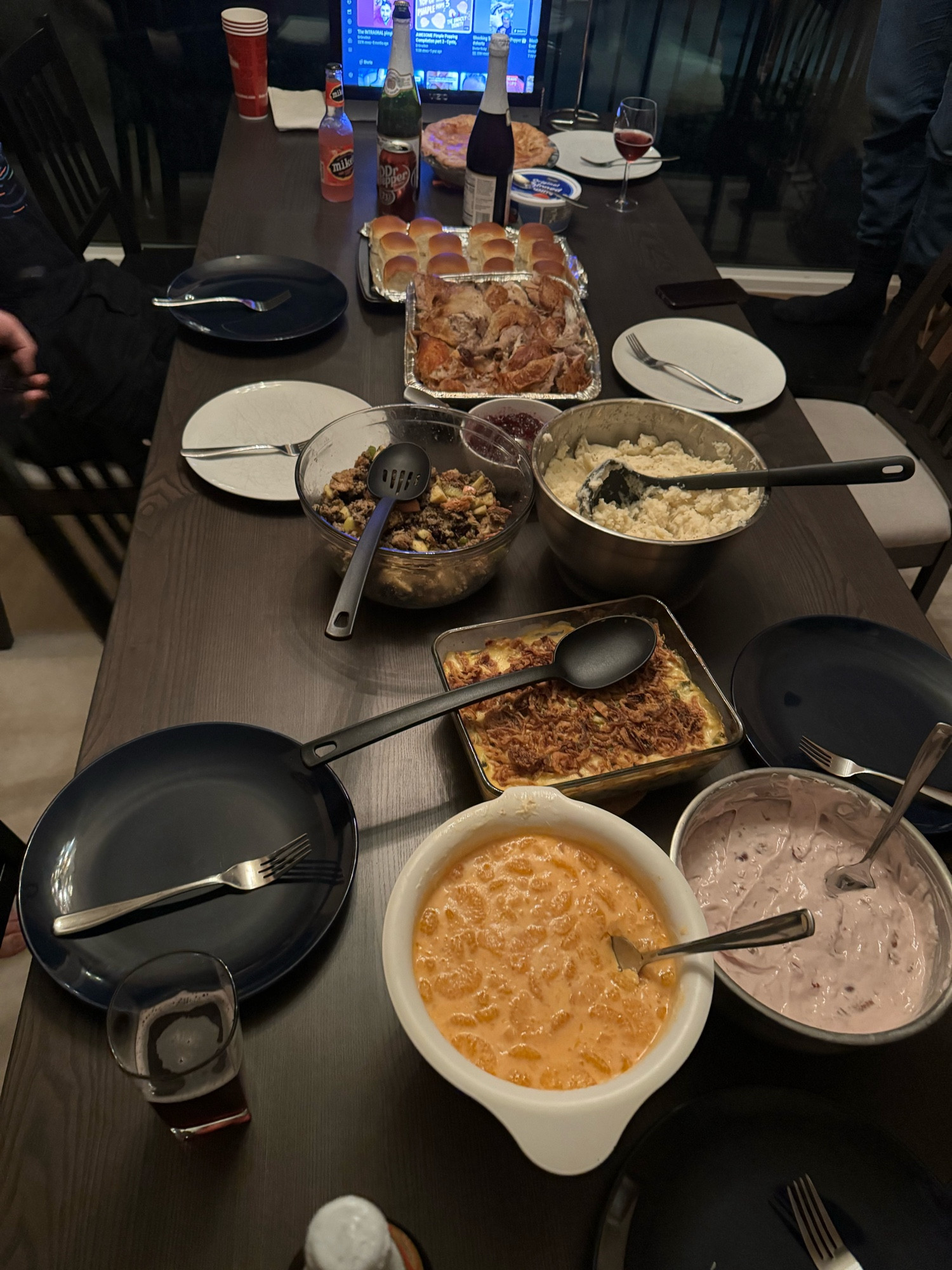 a dinner table with (from back to front)
apple pie,
rolls
turkey
cranberry sauce
stuffing
mashed potatoes
grean bean casserole
orange salad
cherry salad