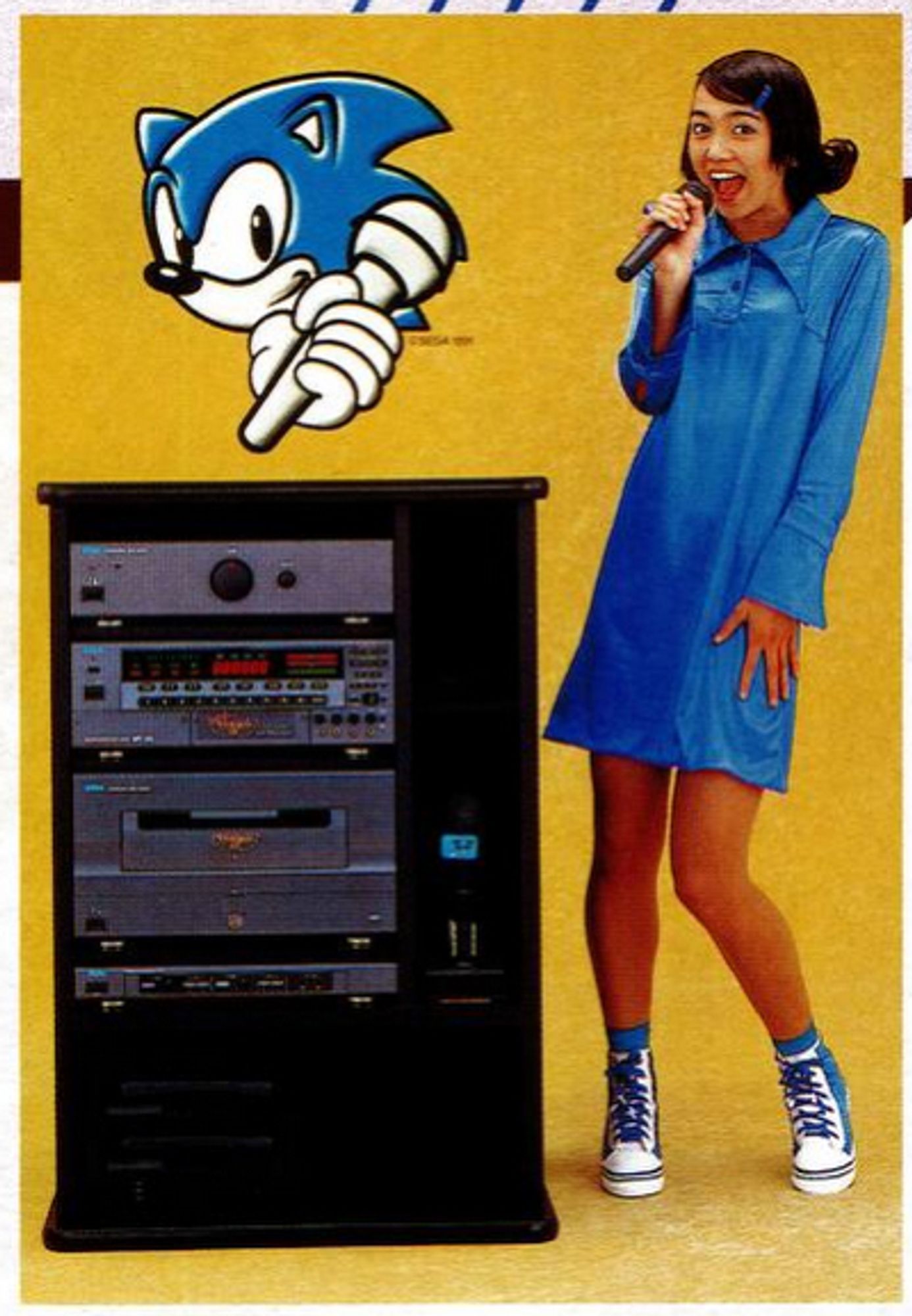 a woman in a blue dress, holding a microphone, standing next to a large, bulky set of audio equipment in a cabinet. there is an image of sonic's head with his hand holding a microphone above the audio equipment.