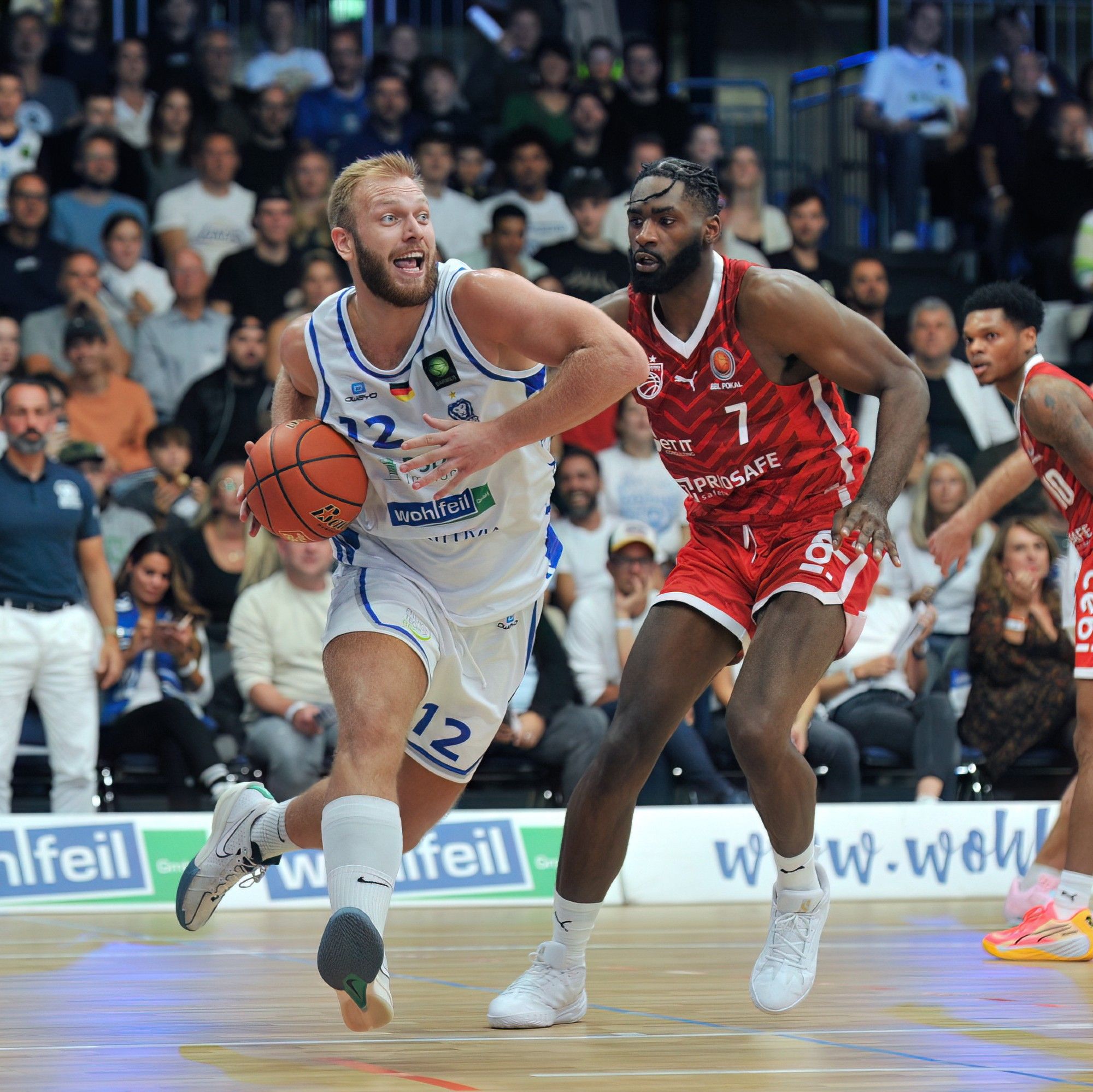 Melvin Jostmann (PS Karlsruhe LIONS, #12) gegen KeyShawn Feazell (Bamberg Baskets, #7) beim Spiel in der 1. Pokalrunde beim BBL-Pokal, PS Karlsruhe LIONS - Bamberg Baskets in der Europahalle.