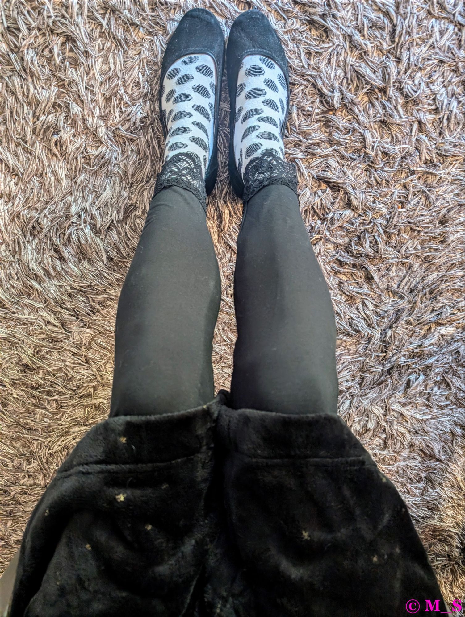 Meine Beine in schwarzen Leggings mit Spitzen an den Füßen. Dazu weiße Socken mit schwarzen großen Punkten, die aus Streifen zusammengesetzt sind. Oben ist ein Stück meines schwarzen Kuschelbademantels mit kleinen, goldenen Sternen zu sehen.