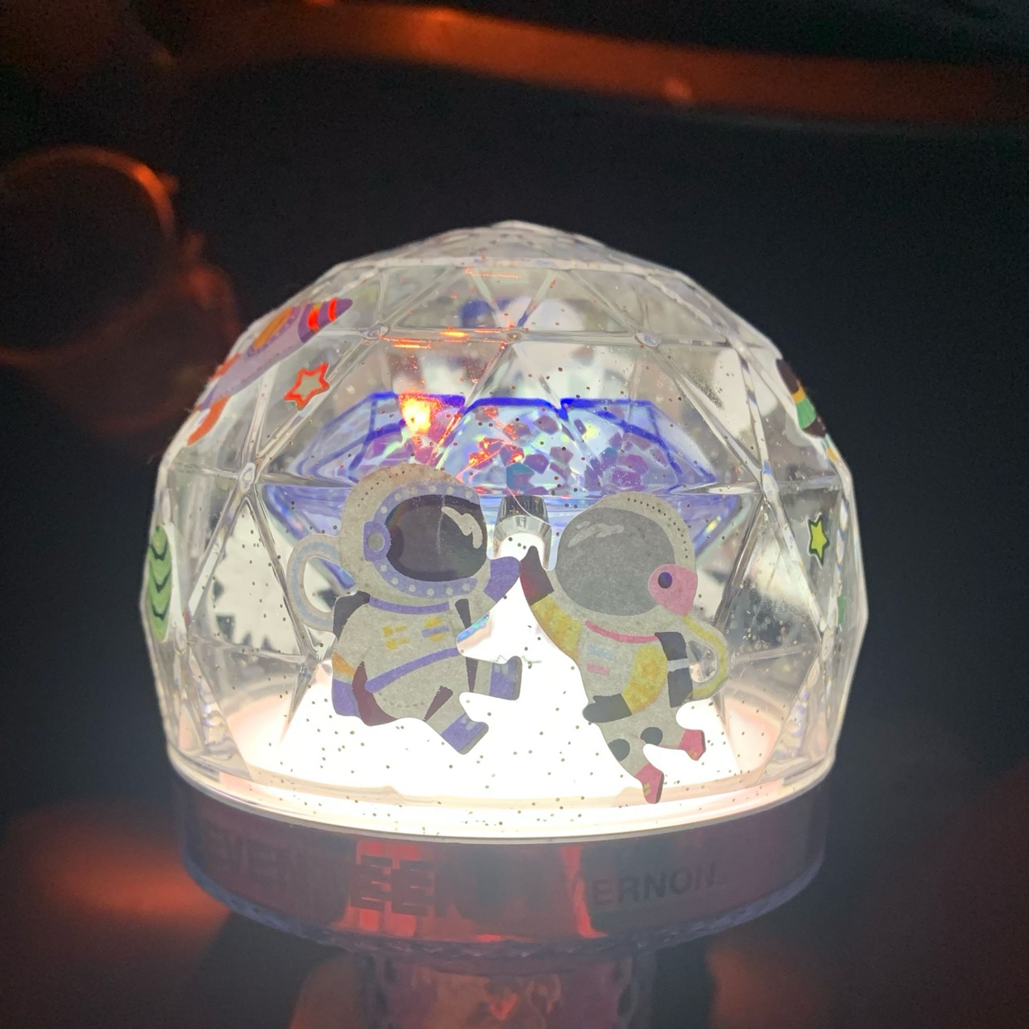 Photo of a Seventeen lightstick lit up in white and decorated with astronaut stickers