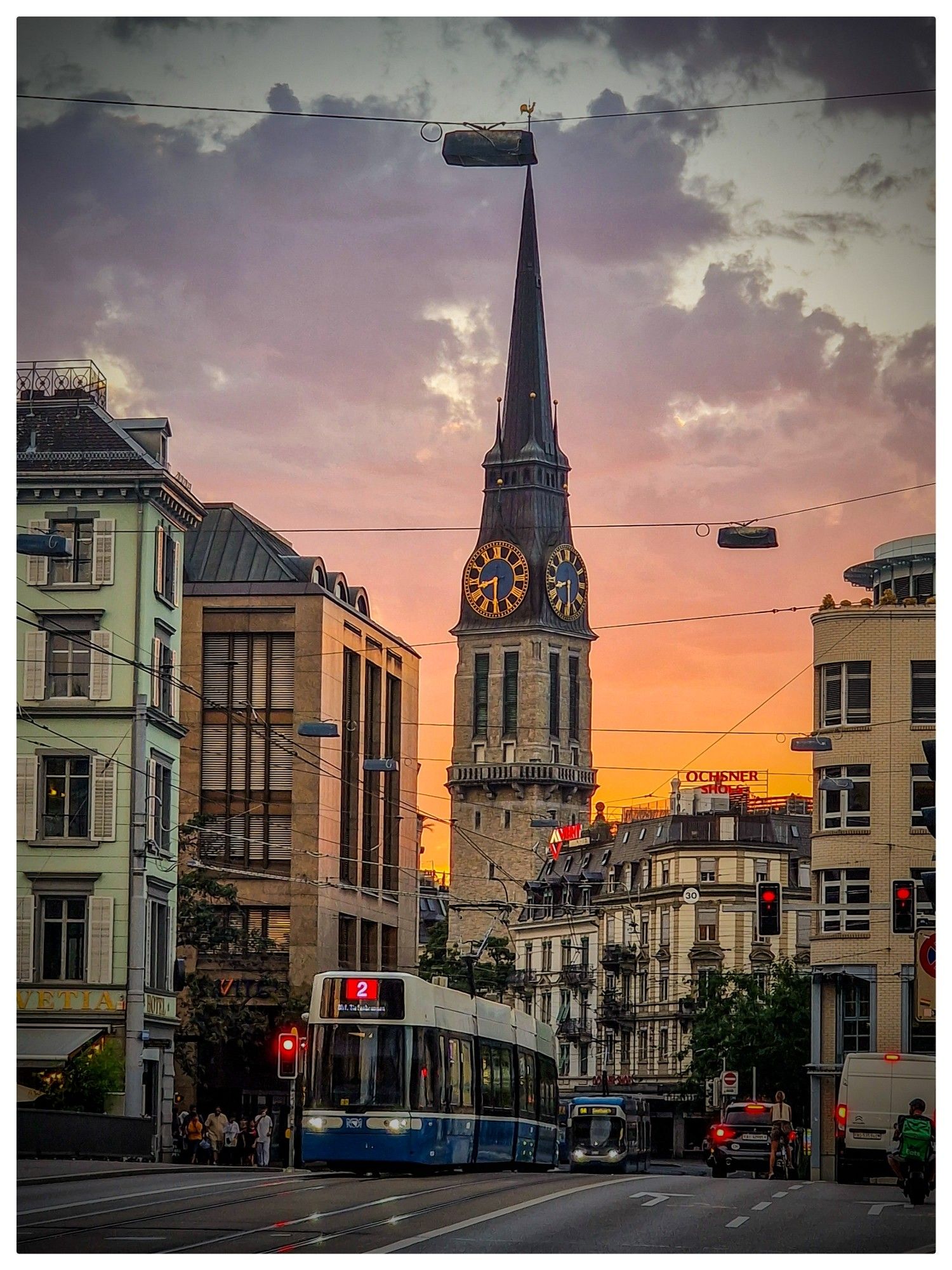 Photo de rue à Zurich au coucher du soleil avec le clocher de St Jakob